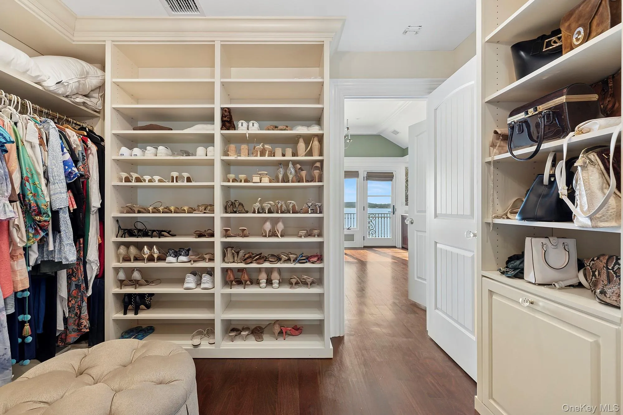 Walk in closet featuring dark wood-style flooring Walk in closet featuring dark wood-style flooring