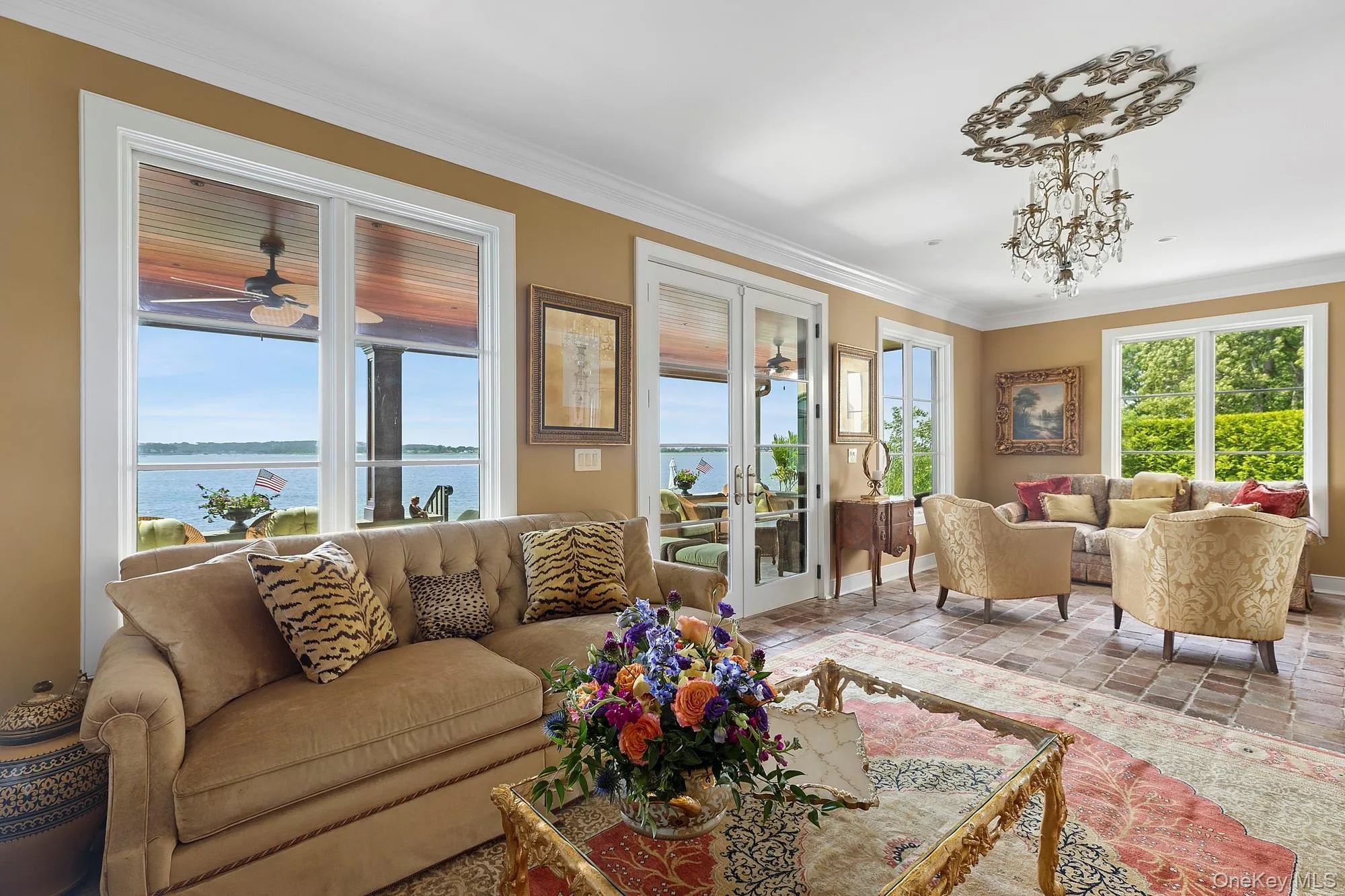 Living room featuring ornamental molding, a water view, and a ceiling fan Living room featuring ornamental molding, a water view, and a ceiling fan