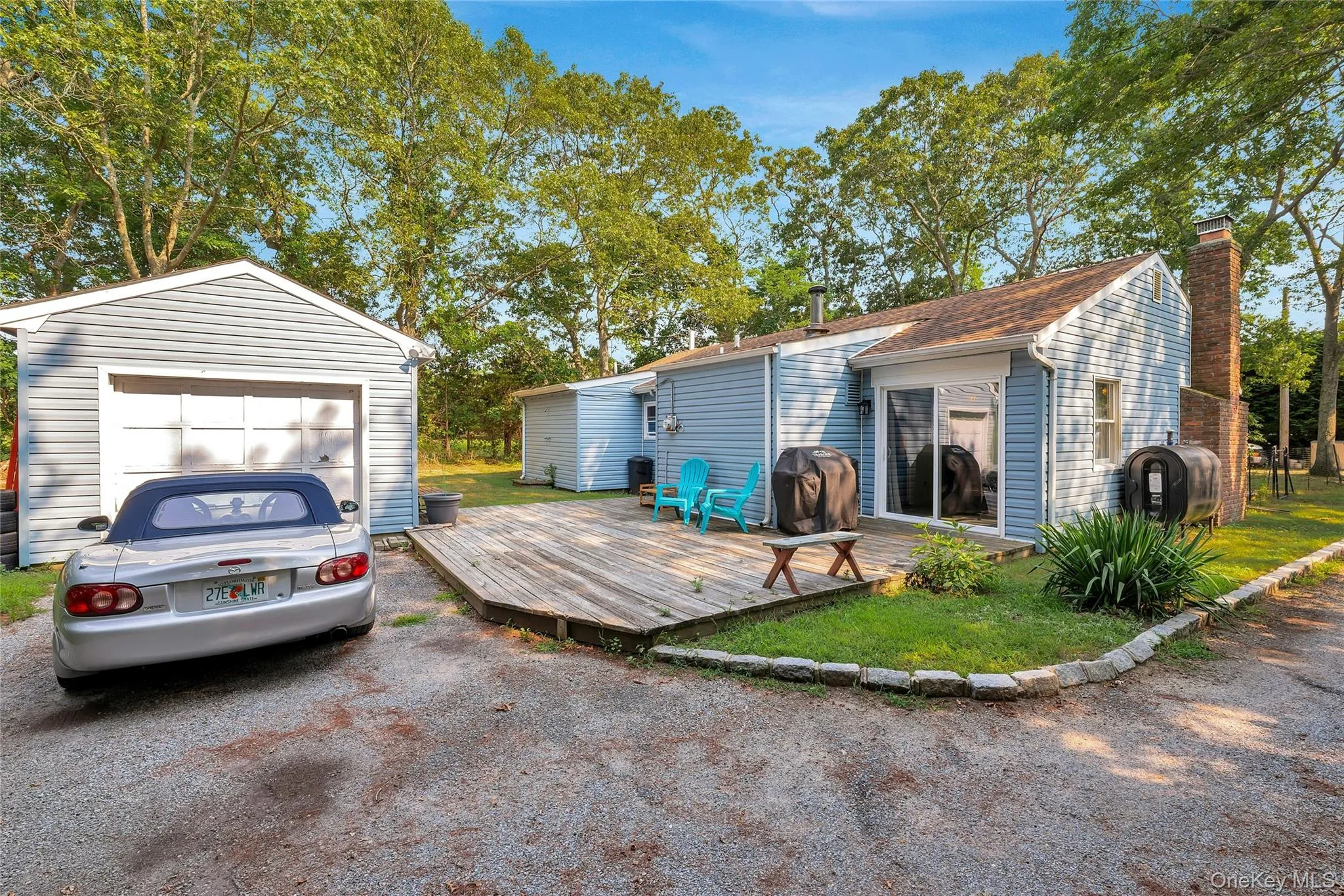 Back of property with view of large back deck and detached garage. Back of property with view of large back deck and detached garage.