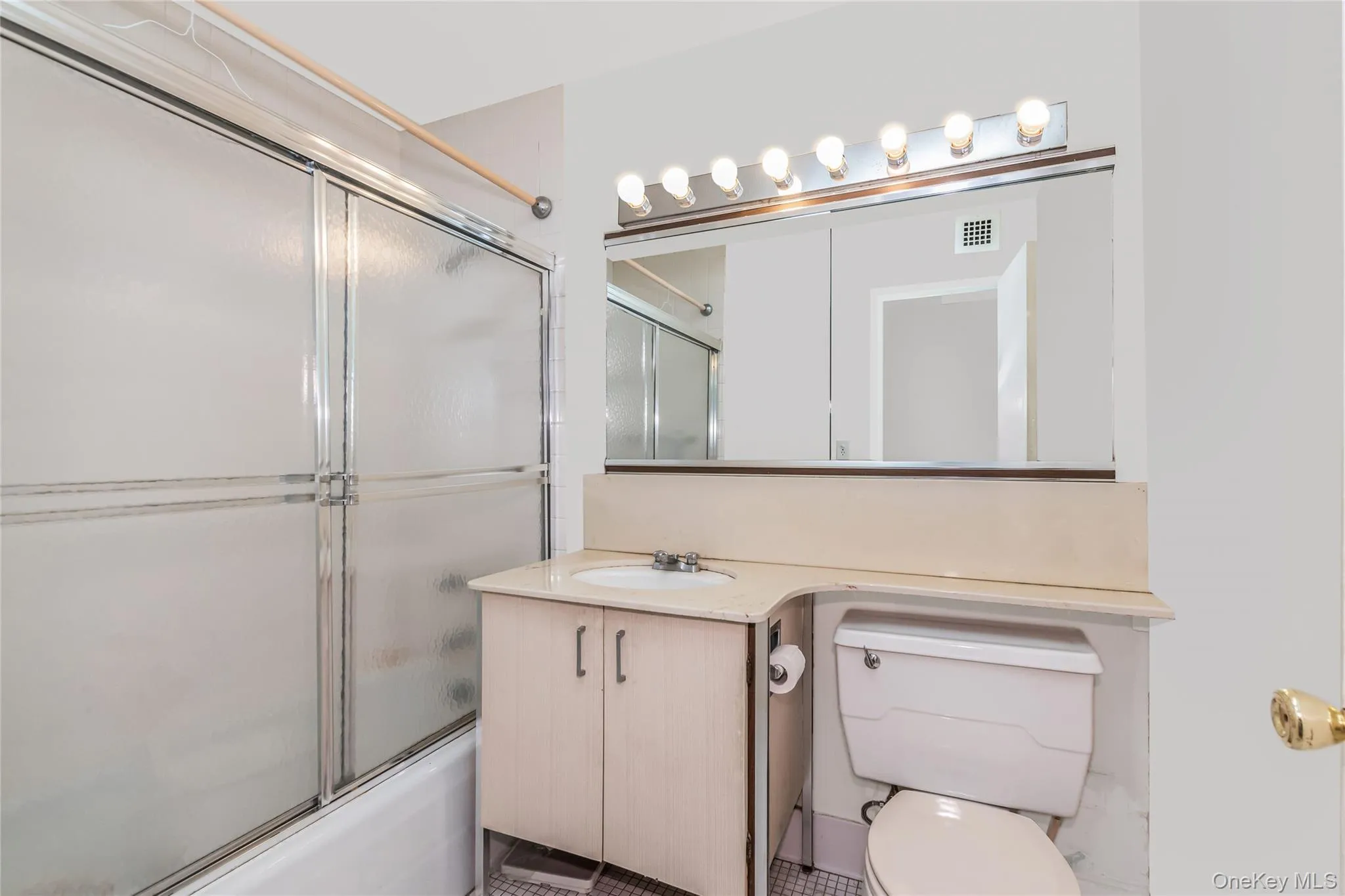 Full bathroom featuring shower / bath combination with glass door and vanity Full bathroom featuring shower / bath combination with glass door and vanity