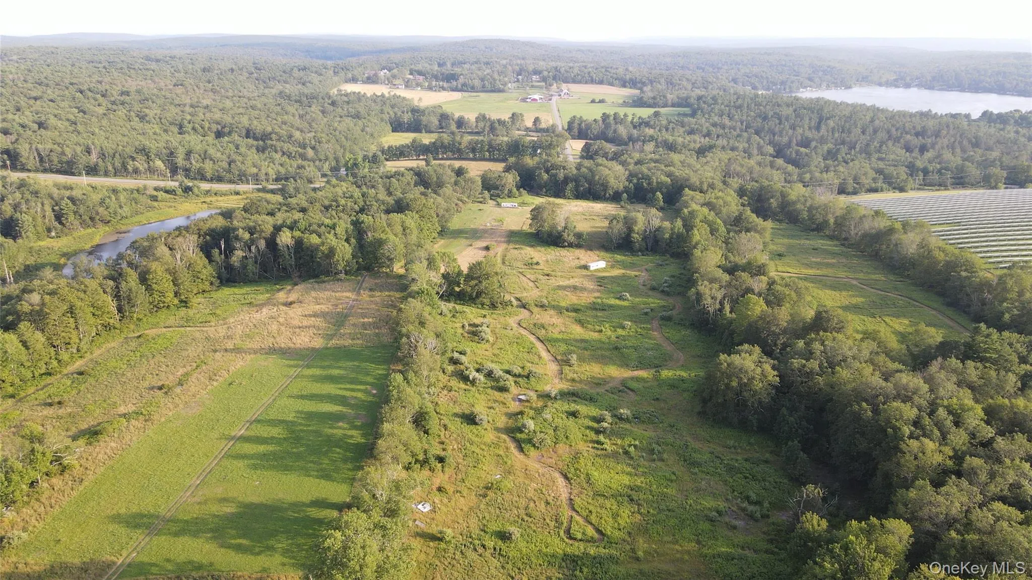 Aerial view of property and surrounding area featuring a large body of water and rural landscape Aerial view of property and surrounding area featuring a large body of water and rural landscape
