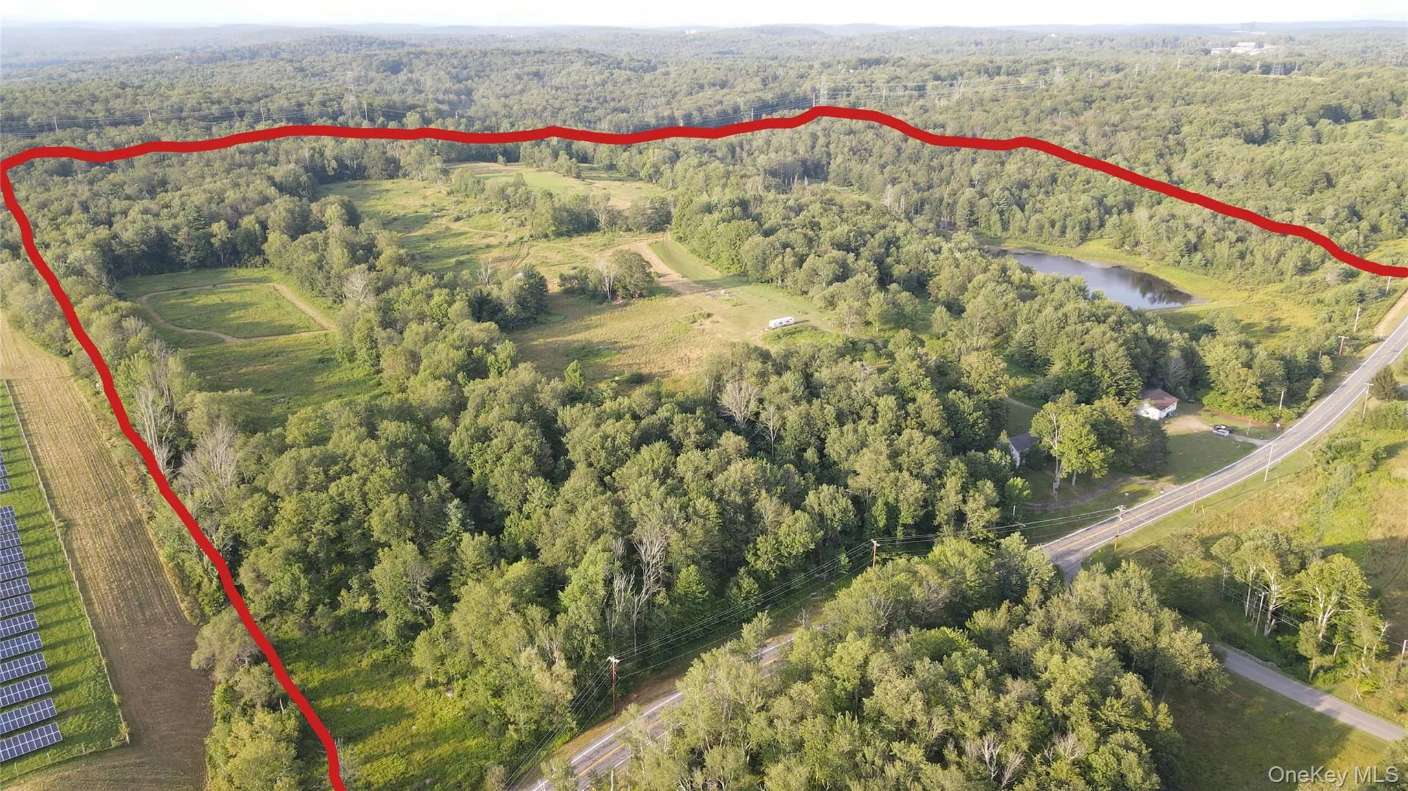 Aerial view of property and surrounding area featuring property parcel outlined and a nearby body of water Aerial view of property and surrounding area featuring property parcel outlined and a nearby body of water