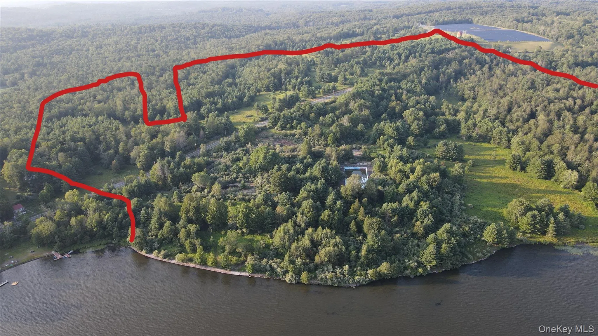Aerial view of property and surrounding area featuring a forest and property boundaries highlighted Aerial view of property and surrounding area featuring a forest and property boundaries highlighted
