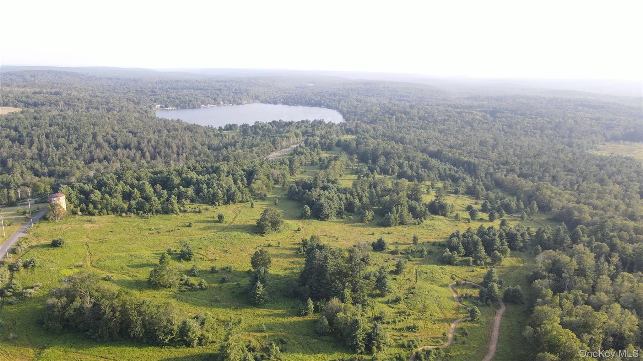 Aerial overview of property's location featuring a heavily wooded area and a large body of water Aerial overview of property's location featuring a heavily wooded area and a large body of water