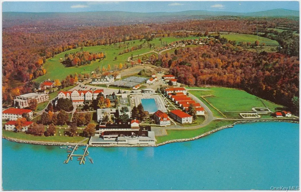 Aerial overview of property's location featuring a large body of water and a forest Aerial overview of property's location featuring a large body of water and a forest