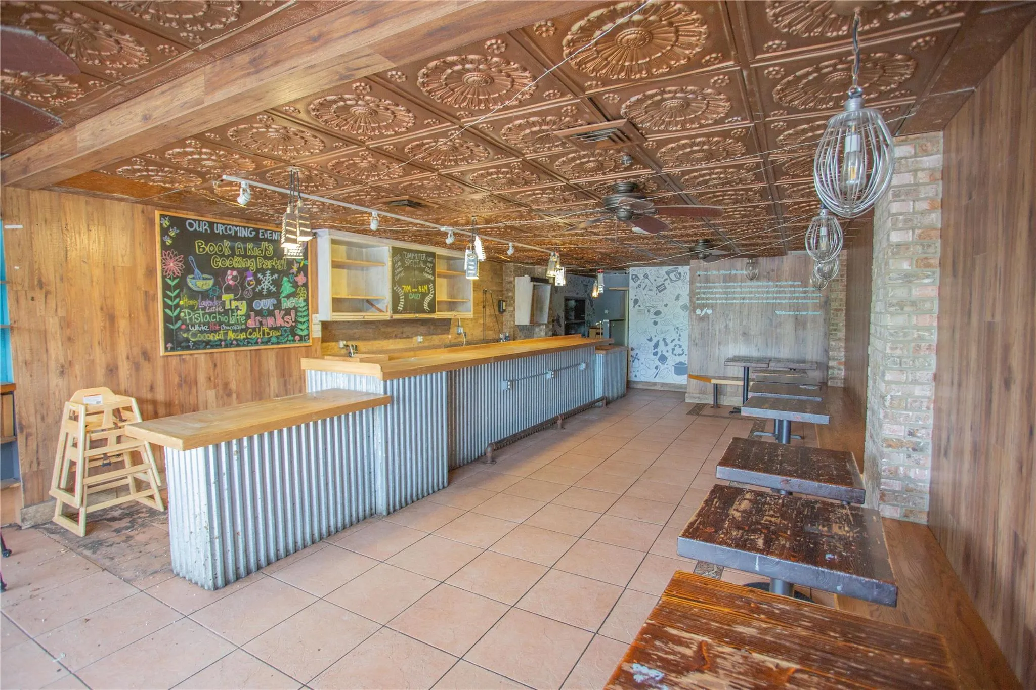 Kitchen featuring butcher block countertops, wood walls, an ornate ceiling, tile patterned flooring, and ceiling fan Kitchen featuring butcher block countertops, wood walls, an ornate ceiling, tile patterned flooring, and ceiling fan