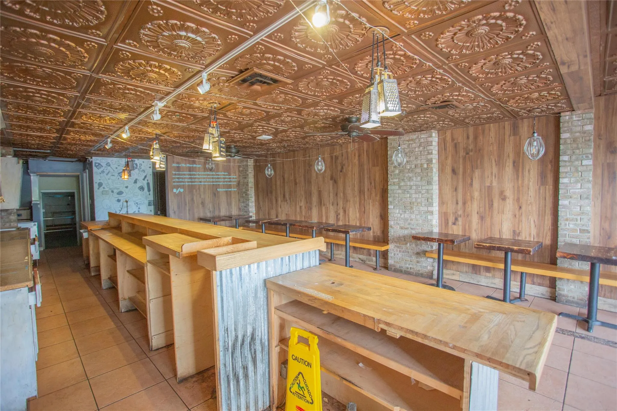 Kitchen featuring an ornate ceiling, tile patterned floors, and wooden walls Kitchen featuring an ornate ceiling, tile patterned floors, and wooden walls