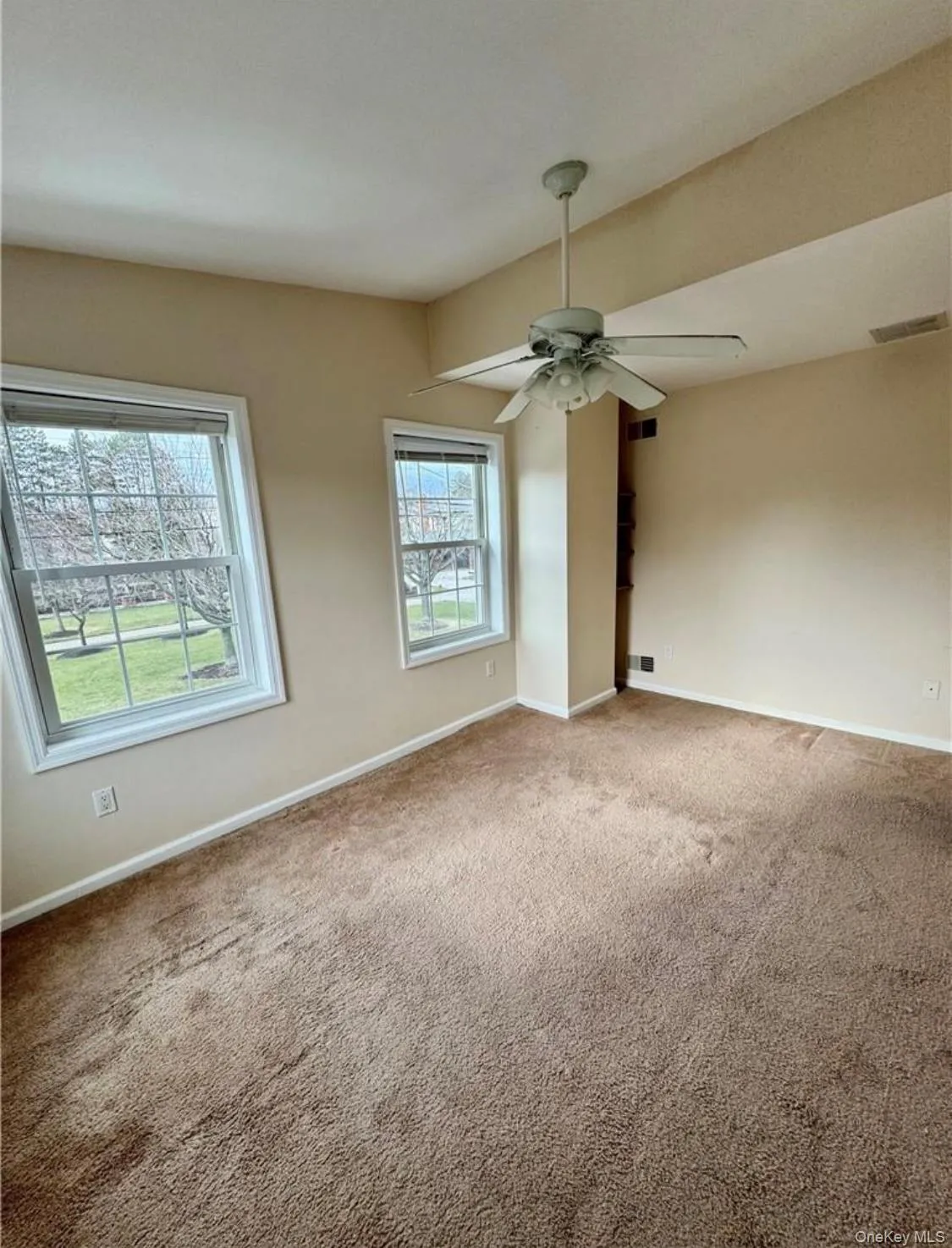 Carpeted spare room with baseboards and a ceiling fan Carpeted spare room with baseboards and a ceiling fan