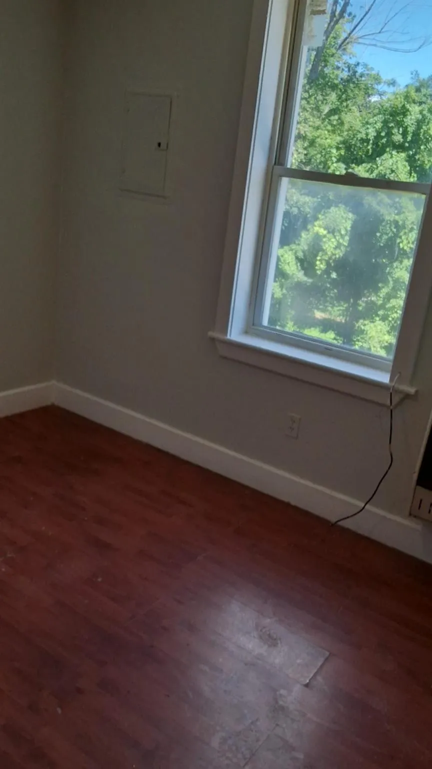 Spare room featuring baseboards and wood finished floors Spare room featuring baseboards and wood finished floors