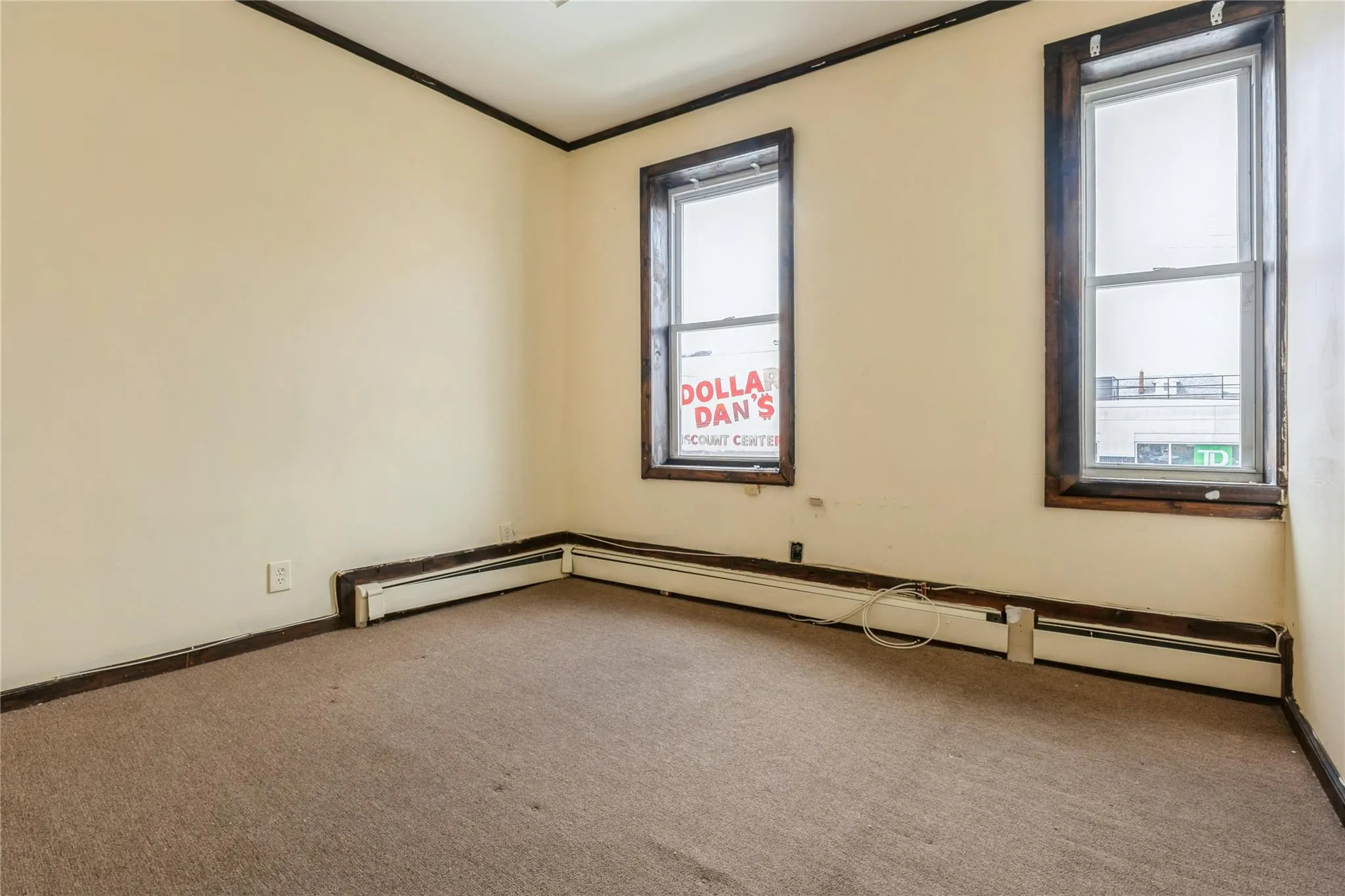 Empty room with carpet, healthy amount of natural light, ornamental molding, and a baseboard radiator Empty room with carpet, healthy amount of natural light, ornamental molding, and a baseboard radiator