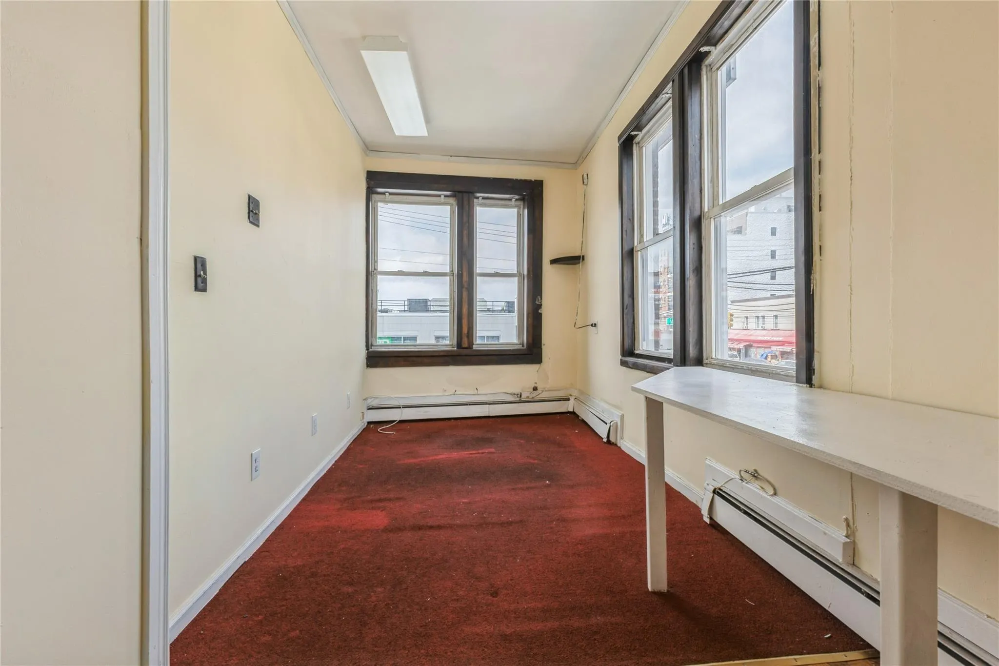 Hall with dark colored carpet and baseboard heating Hall with dark colored carpet and baseboard heating