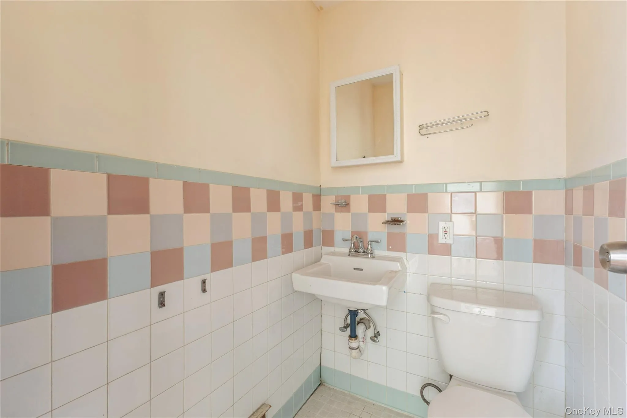 Half bath featuring a wainscoted wall and tile walls Half bath featuring a wainscoted wall and tile walls