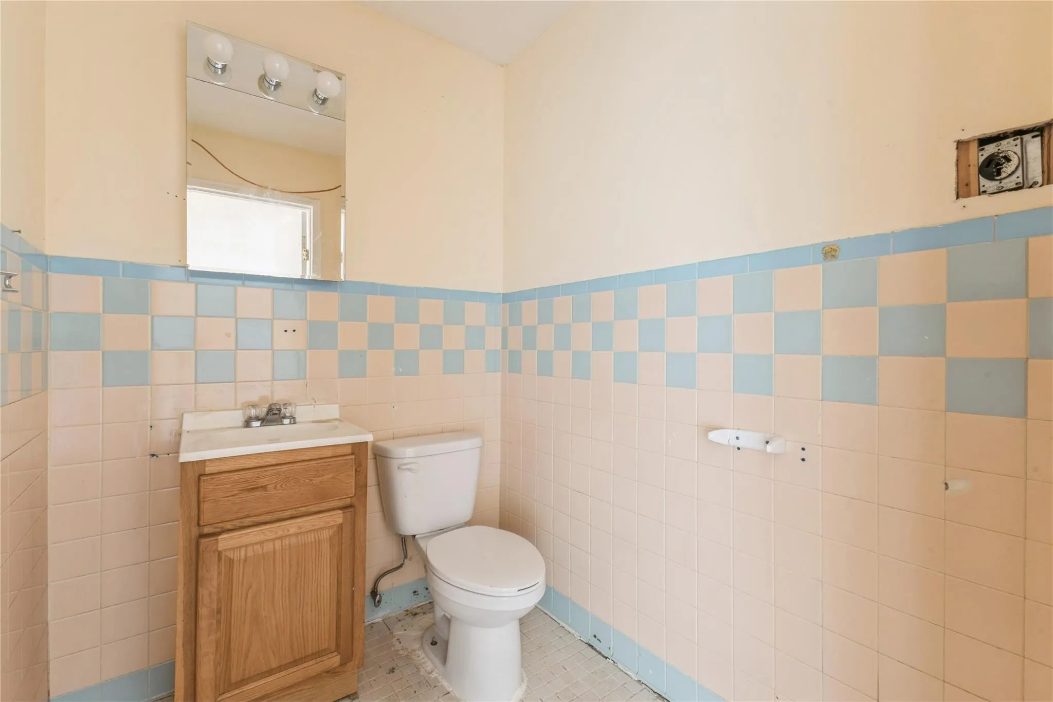 Half bathroom with tile walls, vanity, and wainscoting Half bathroom with tile walls, vanity, and wainscoting