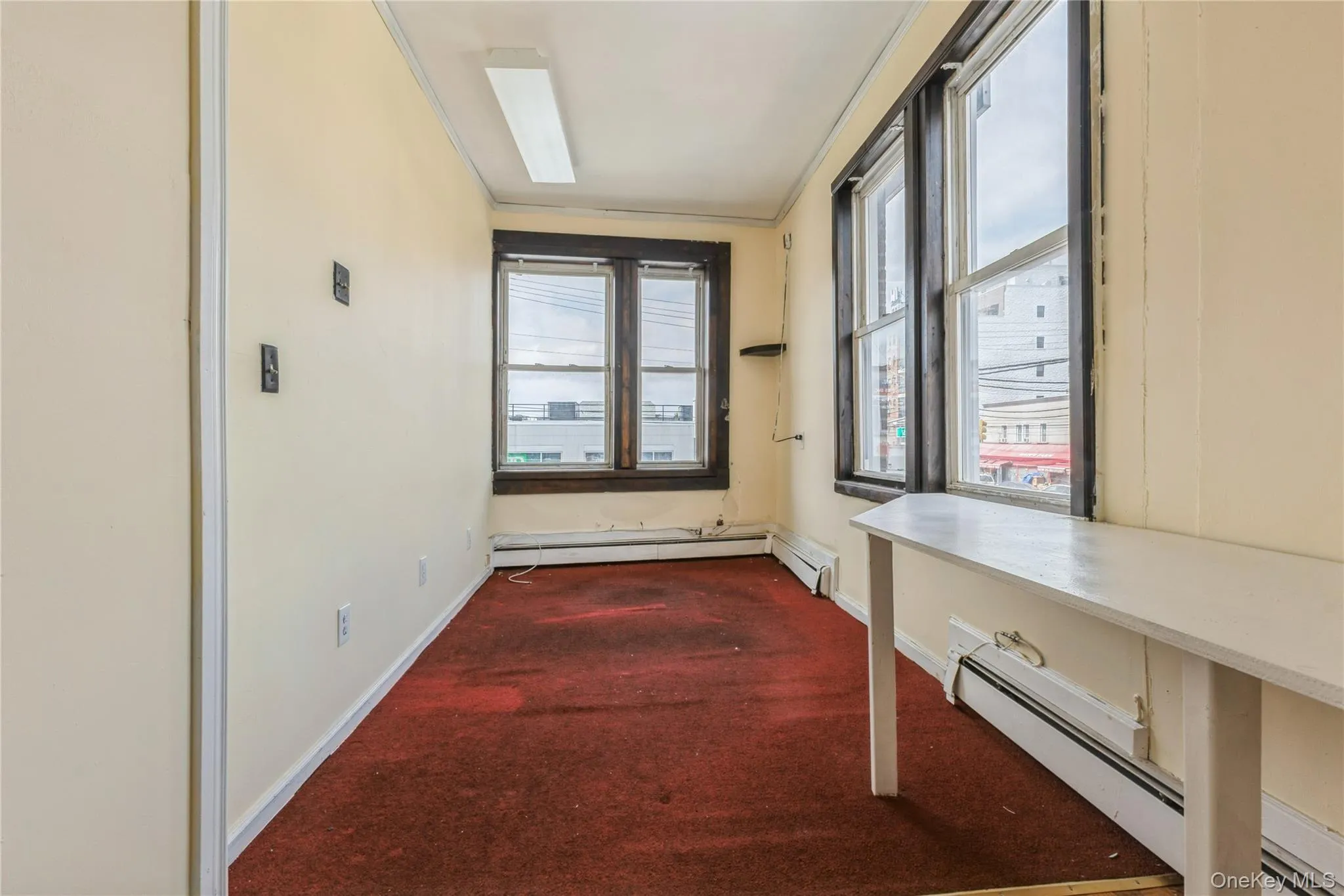 Hall with dark colored carpet and baseboard heating Hall with dark colored carpet and baseboard heating