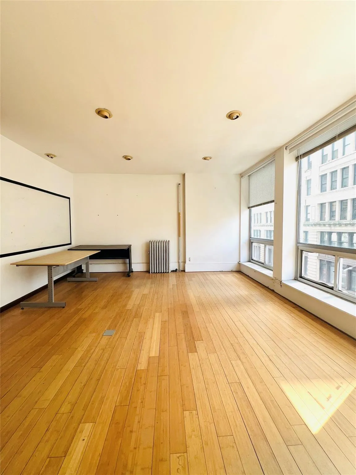Spare room featuring light wood finished floors, baseboard heating, and radiator Spare room featuring light wood finished floors, baseboard heating, and radiator