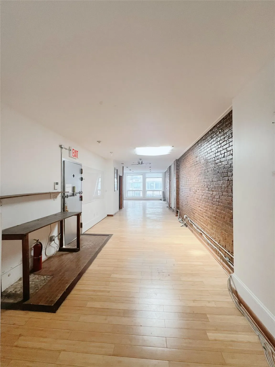 Hall with brick wall and light wood-style floors Hall with brick wall and light wood-style floors