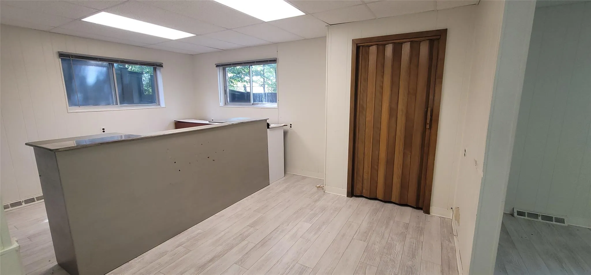 Spare room with light wood-style flooring and a paneled ceiling Spare room with light wood-style flooring and a paneled ceiling