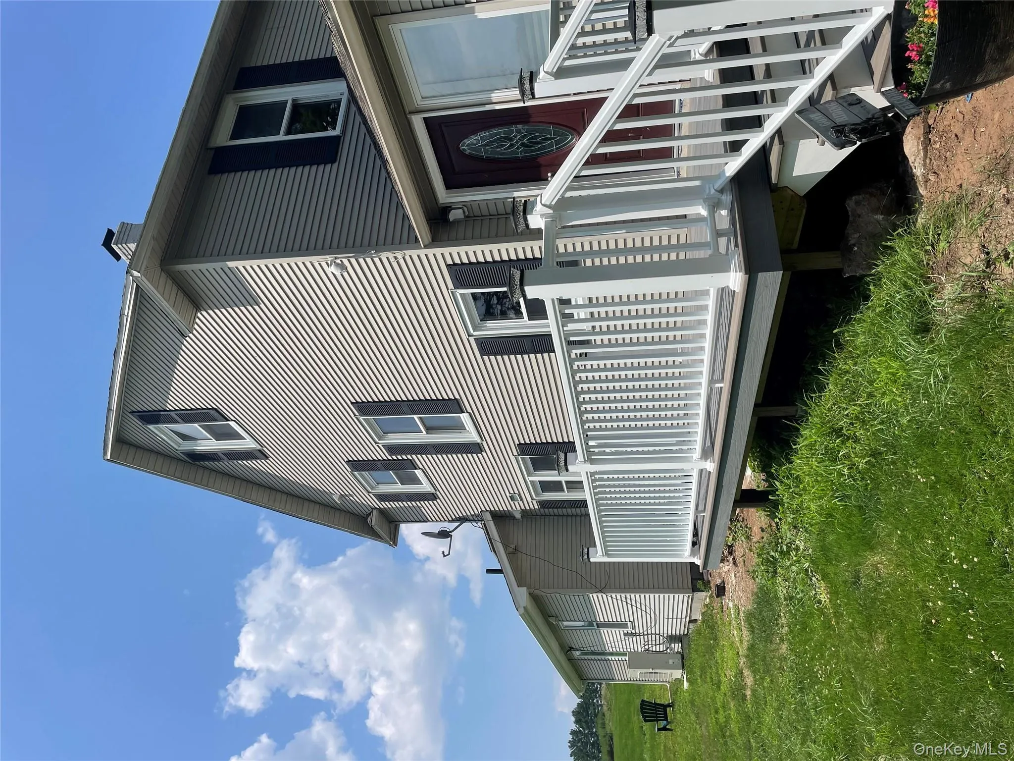 Back of property featuring a wooden deck, a lawn, and a chimney Back of property featuring a wooden deck, a lawn, and a chimney