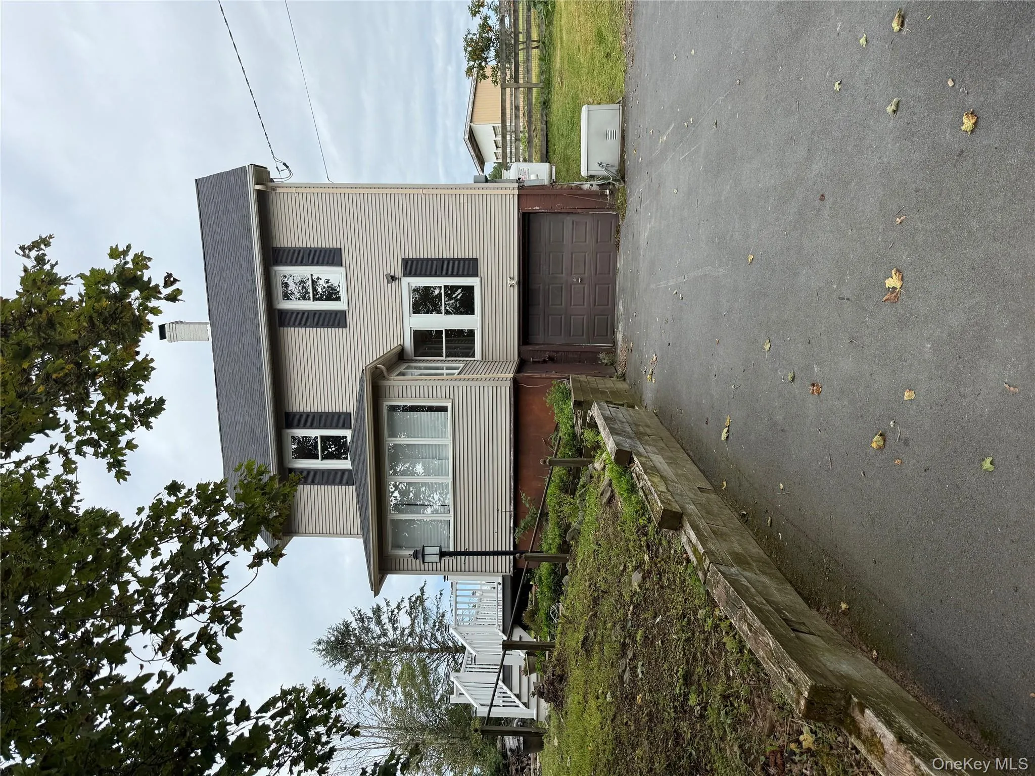 View of front facade with a chimney, driveway, and a garage View of front facade with a chimney, driveway, and a garage