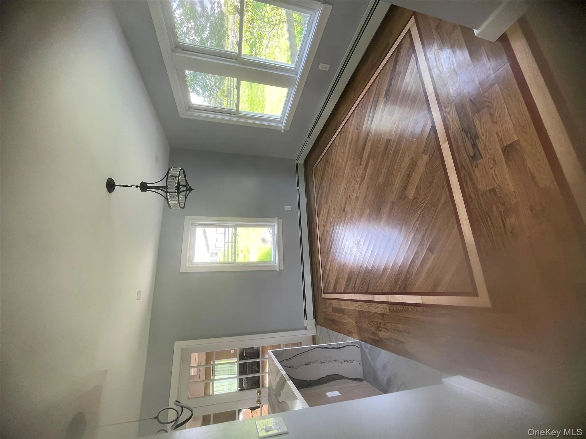 Unfurnished dining area with a baseboard heating unit, a chandelier, and wood finished floors Unfurnished dining area with a baseboard heating unit, a chandelier, and wood finished floors