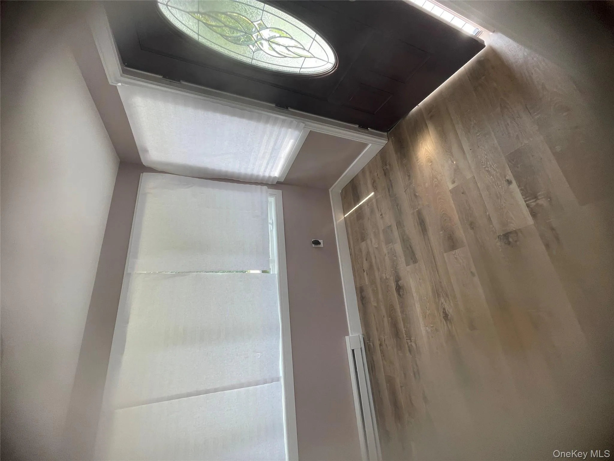 Entryway featuring wood finished floors and a baseboard heating unit Entryway featuring wood finished floors and a baseboard heating unit