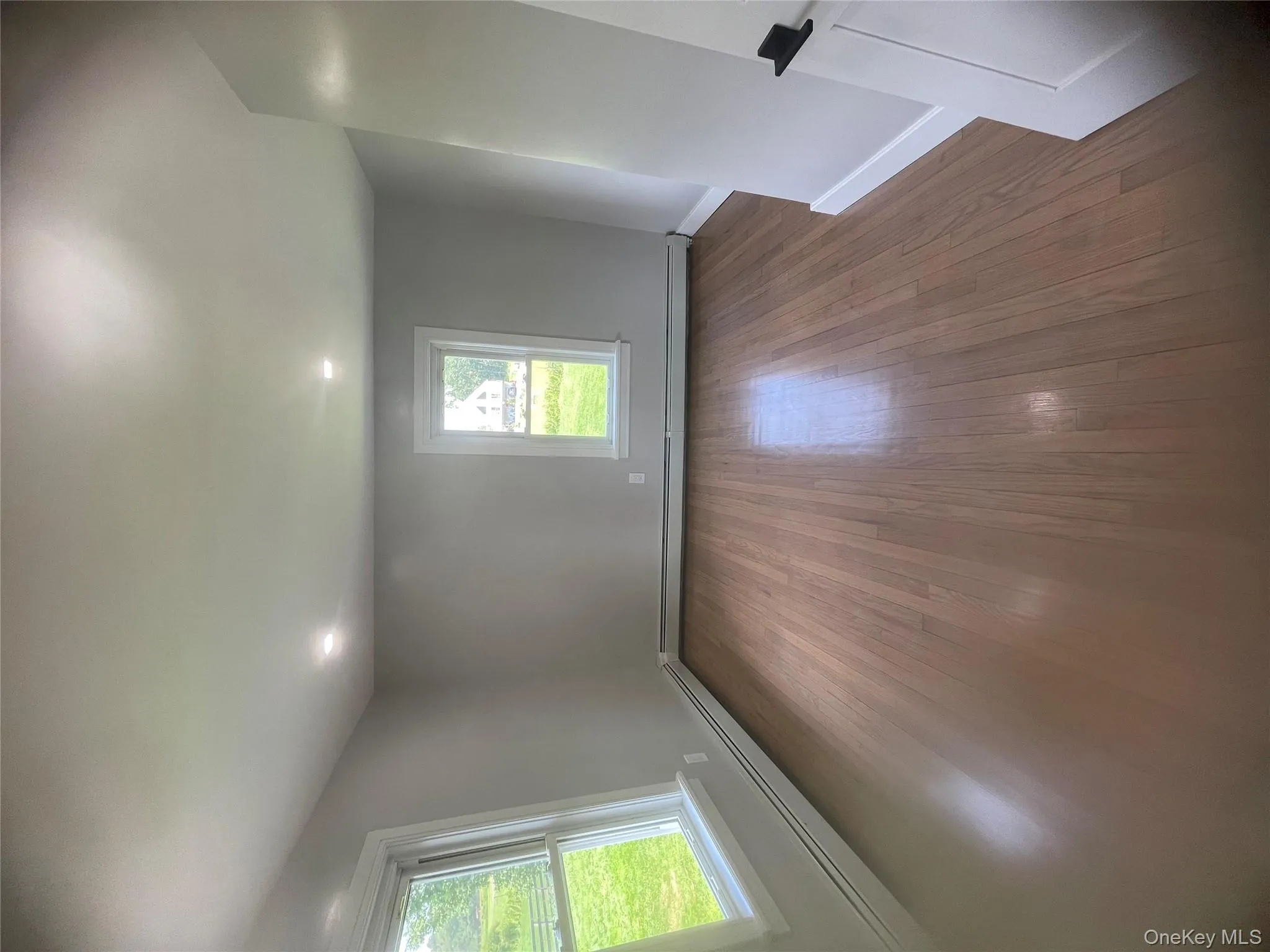 Bedroom with a baseboard radiator, dark wood-type flooring, and recessed lighting Bedroom with a baseboard radiator, dark wood-type flooring, and recessed lighting