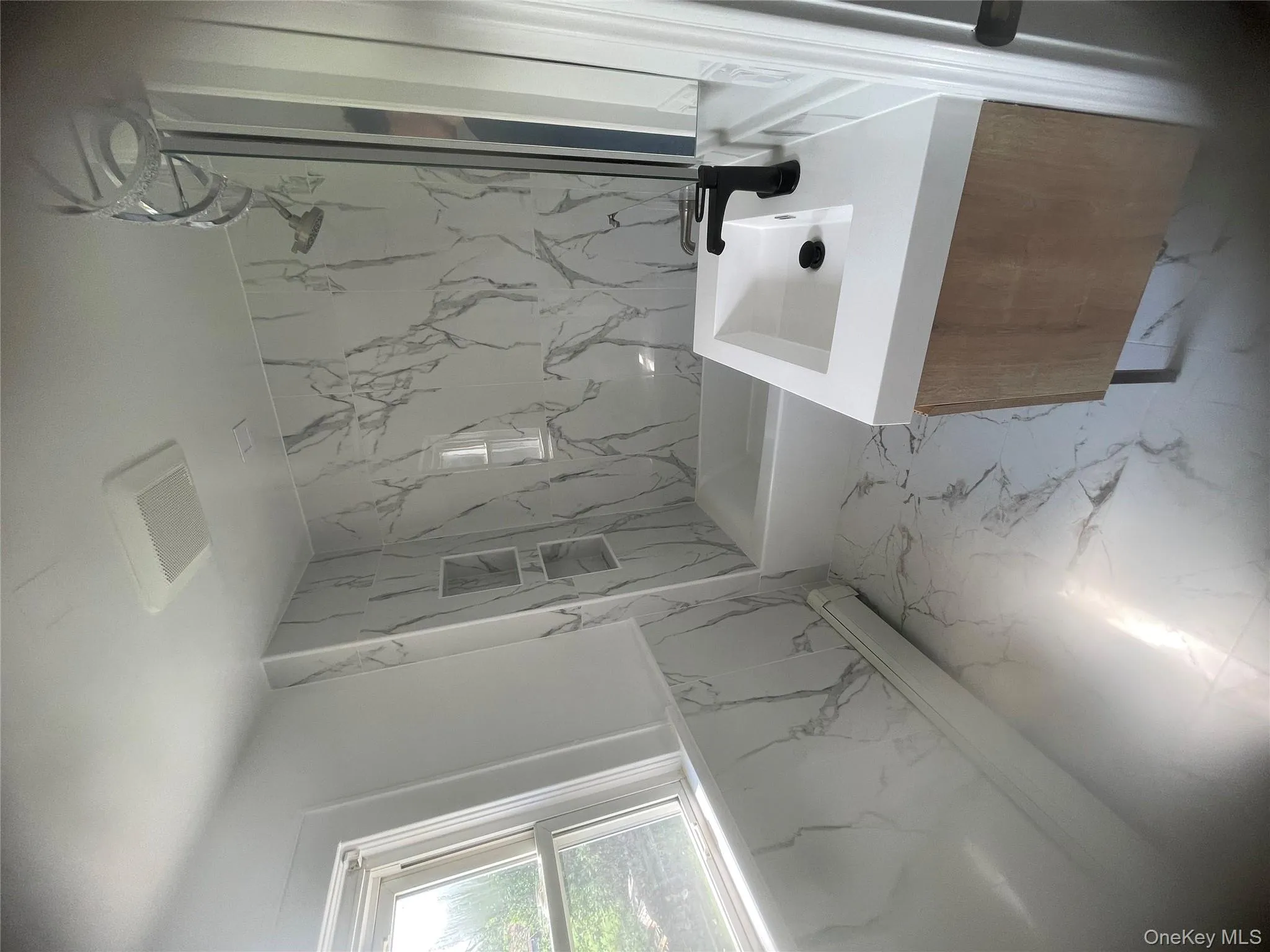 Bathroom with vanity, marble finish flooring, and wainscoting Bathroom with vanity, marble finish flooring, and wainscoting