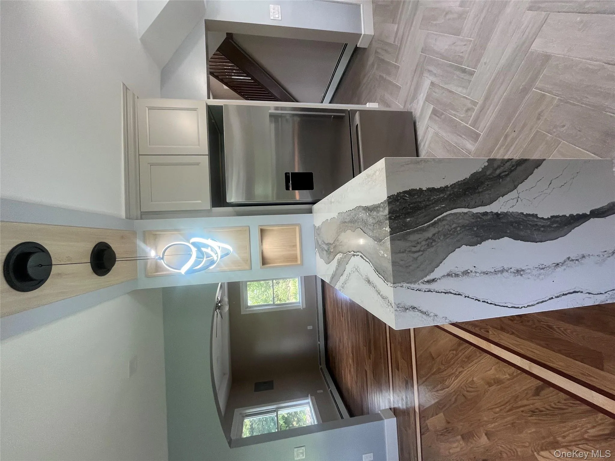 Kitchen featuring fridge, light stone countertops, ceiling fan, a baseboard heating unit, and plenty of natural light Kitchen featuring fridge, light stone countertops, ceiling fan, a baseboard heating unit, and plenty of natural light