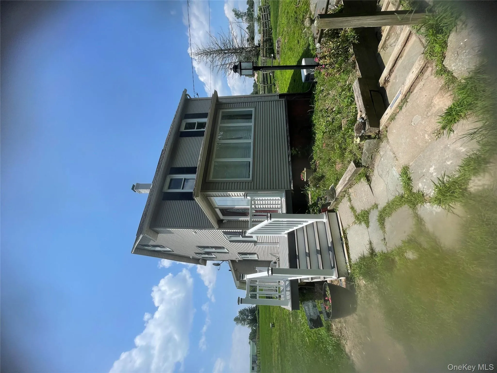 View of front facade with a wooden deck and a chimney View of front facade with a wooden deck and a chimney