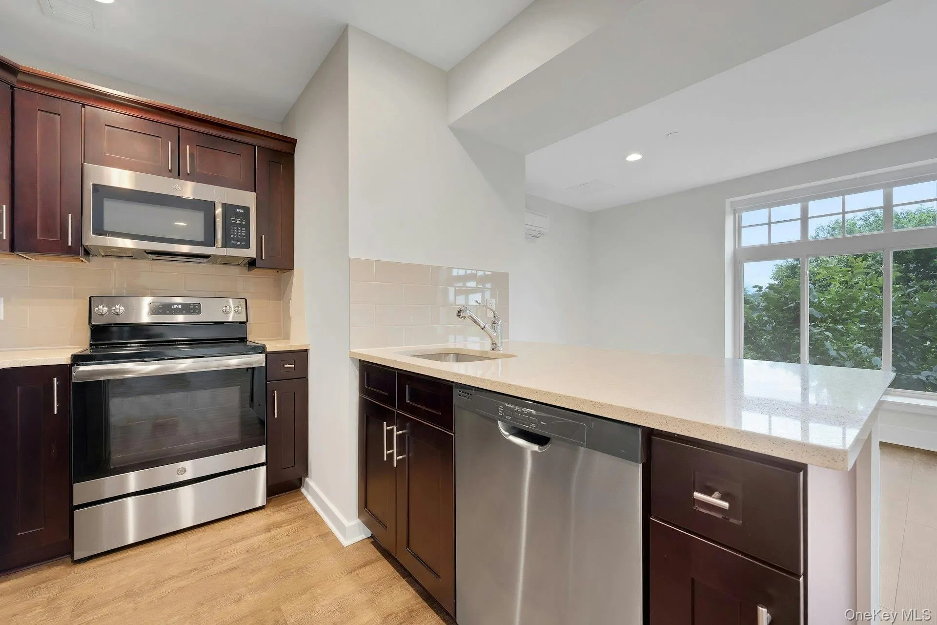 Kitchen featuring appliances with stainless steel finishes, and Quartz peninsula Kitchen featuring appliances with stainless steel finishes, and Quartz peninsula