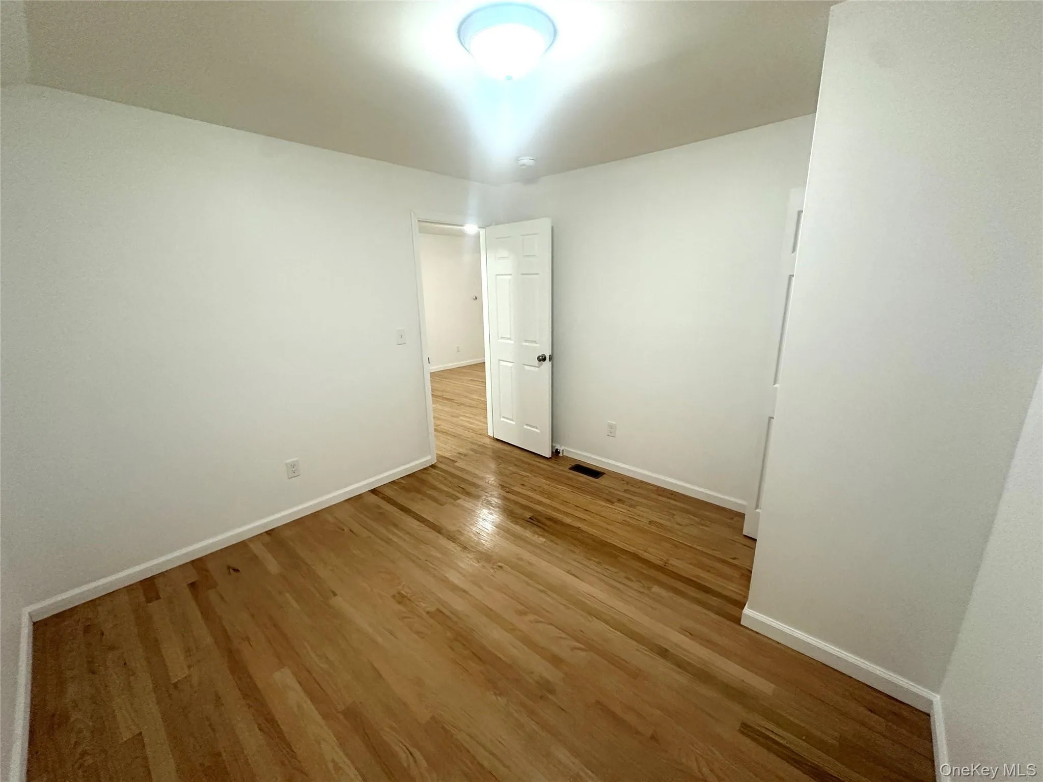 Unfurnished bedroom with light wood-type flooring and baseboards Unfurnished bedroom with light wood-type flooring and baseboards