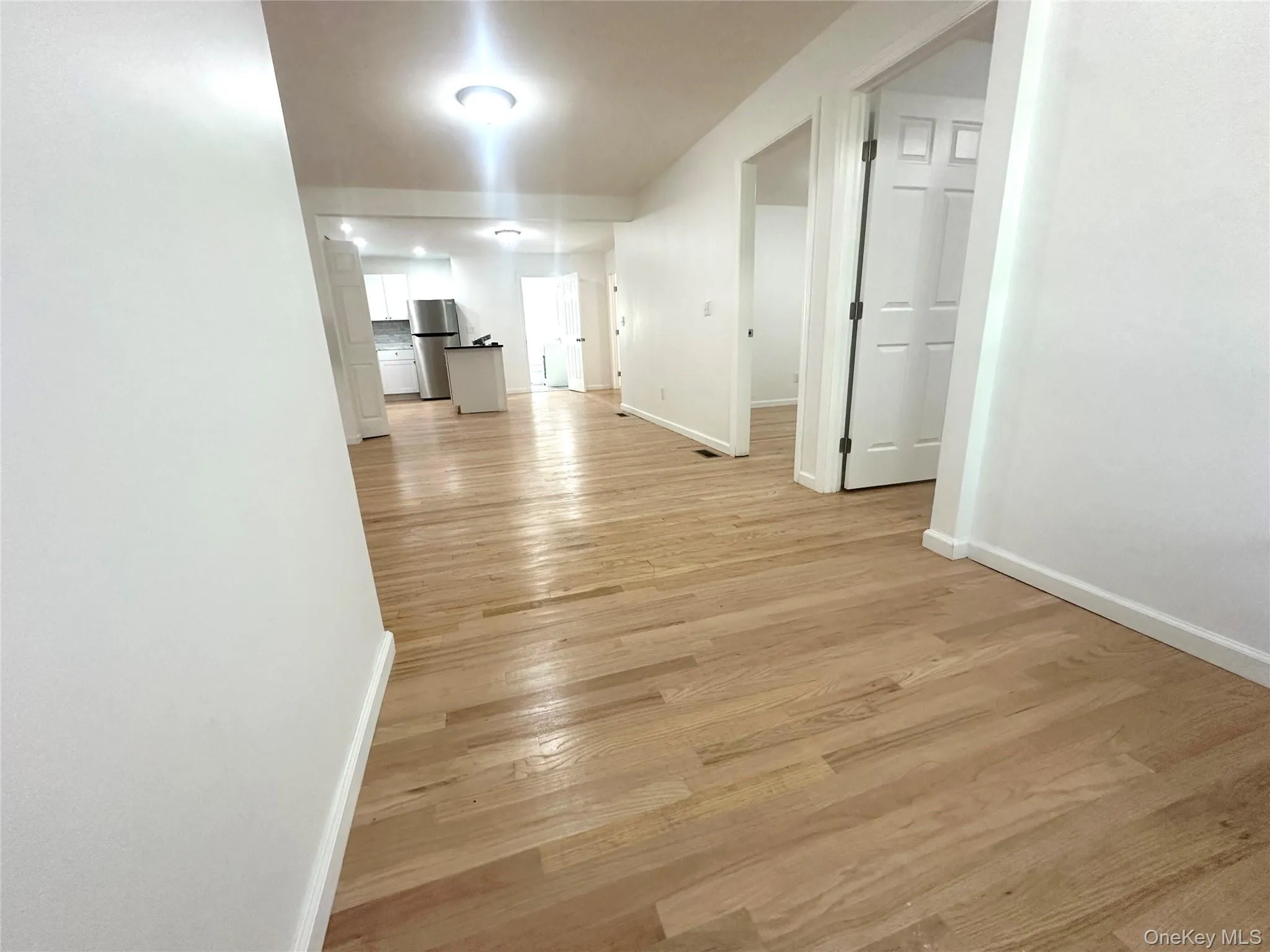 Hall featuring baseboards and light wood-type flooring Hall featuring baseboards and light wood-type flooring