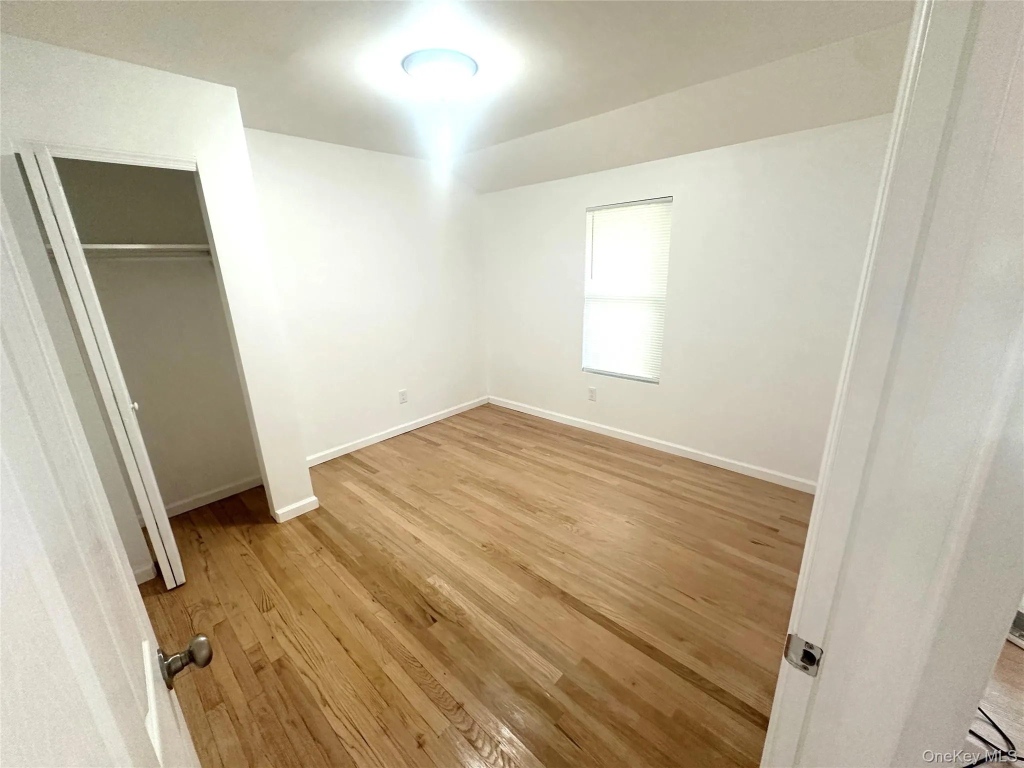 Unfurnished bedroom featuring light wood finished floors and a closet Unfurnished bedroom featuring light wood finished floors and a closet