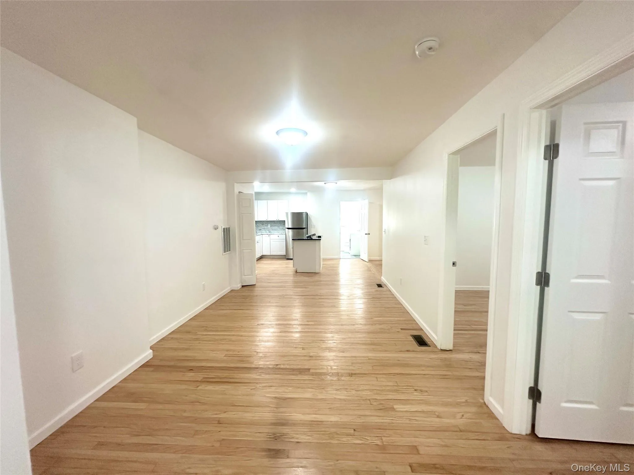 Unfurnished living room with light wood-style floors and baseboards Unfurnished living room with light wood-style floors and baseboards