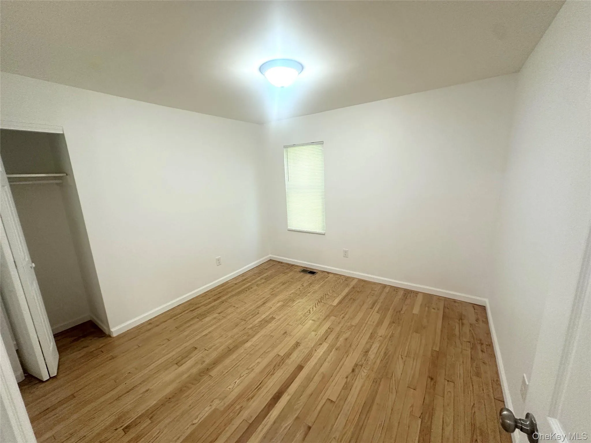 Unfurnished bedroom with light wood-type flooring and a closet Unfurnished bedroom with light wood-type flooring and a closet