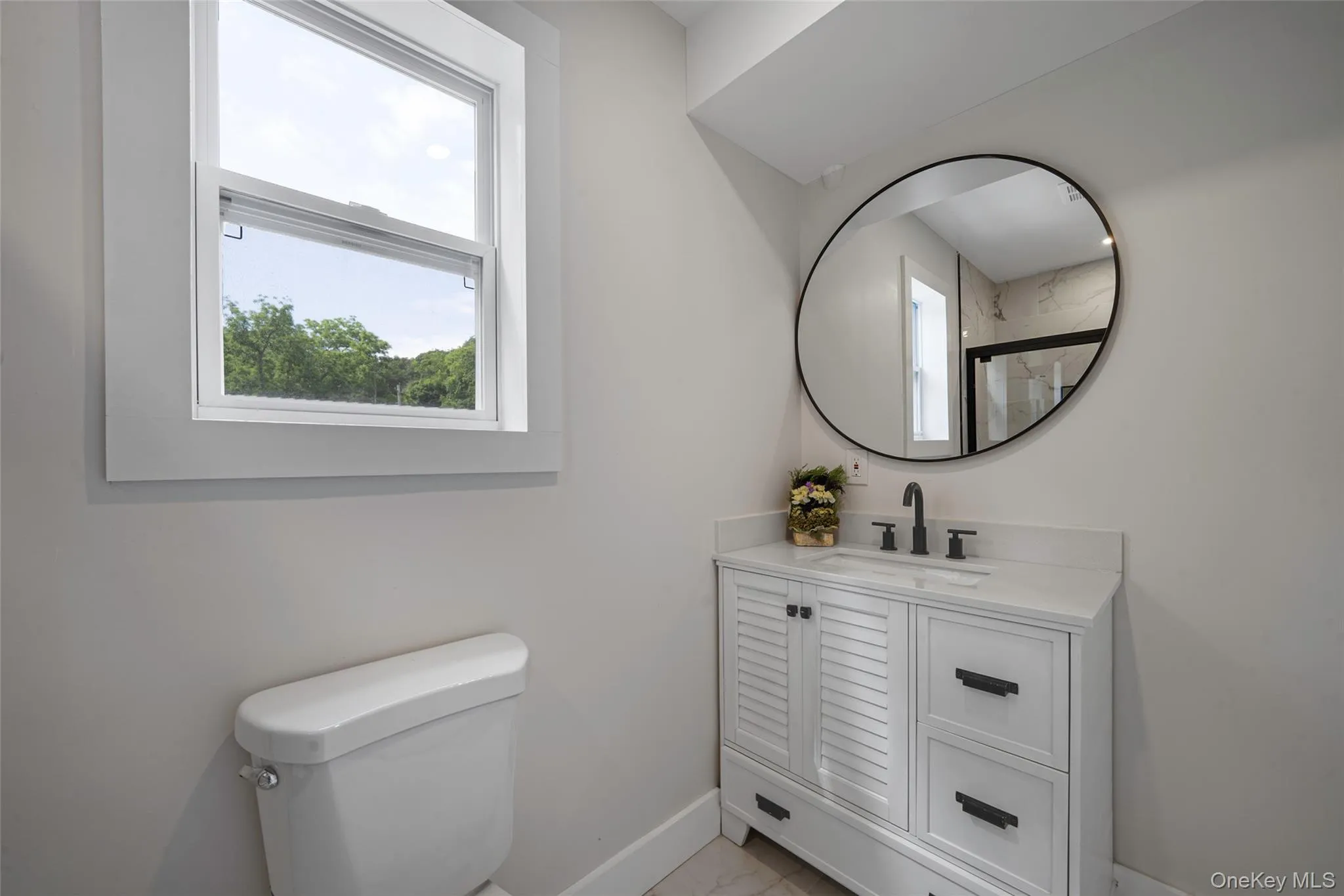 Bathroom featuring vanity, marble look tile flooring, and a shower Bathroom featuring vanity, marble look tile flooring, and a shower