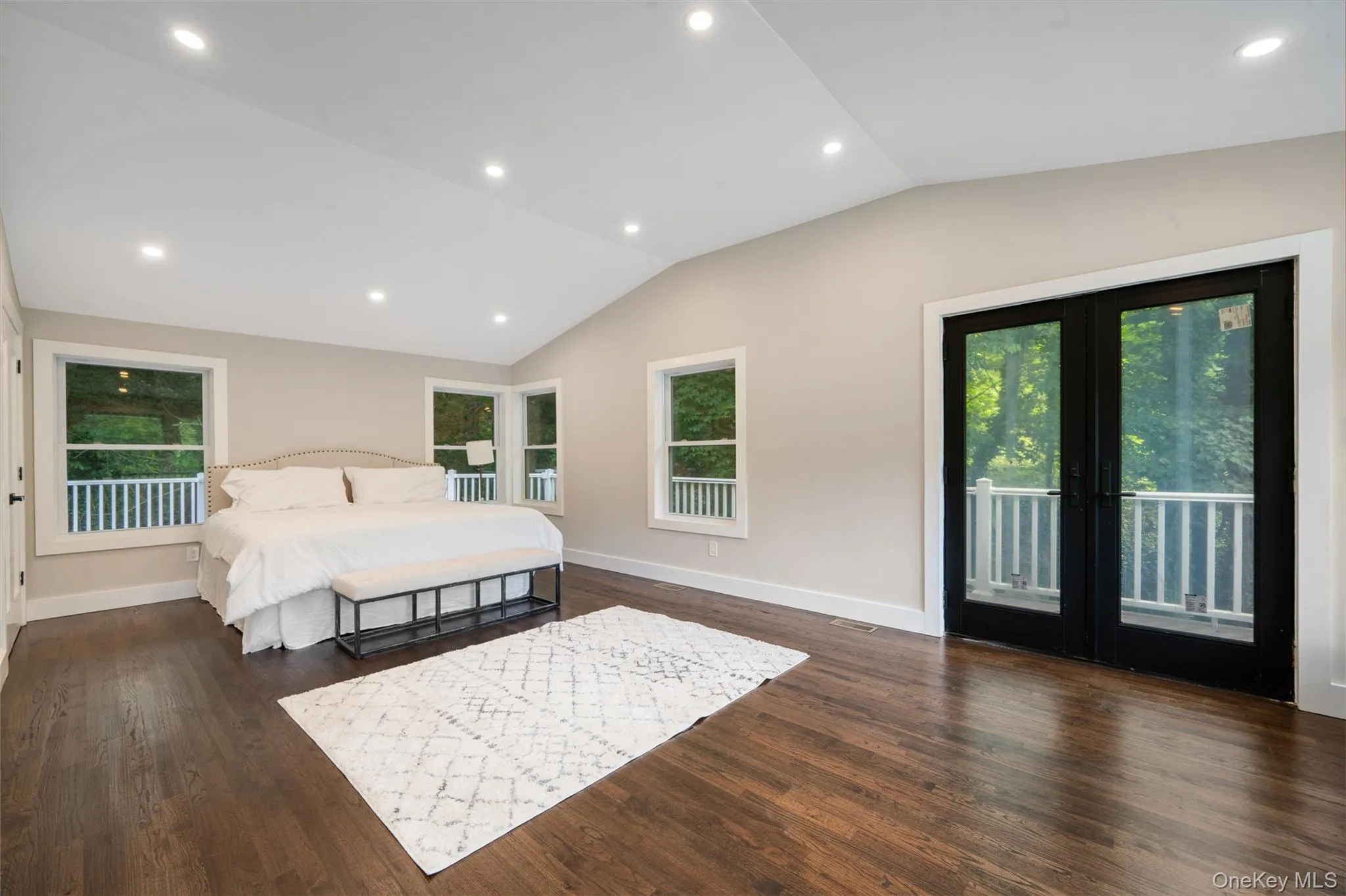 Bedroom with vaulted ceiling, access to exterior, wood finished floors, recessed lighting, and french doors Bedroom with vaulted ceiling, access to exterior, wood finished floors, recessed lighting, and french doors