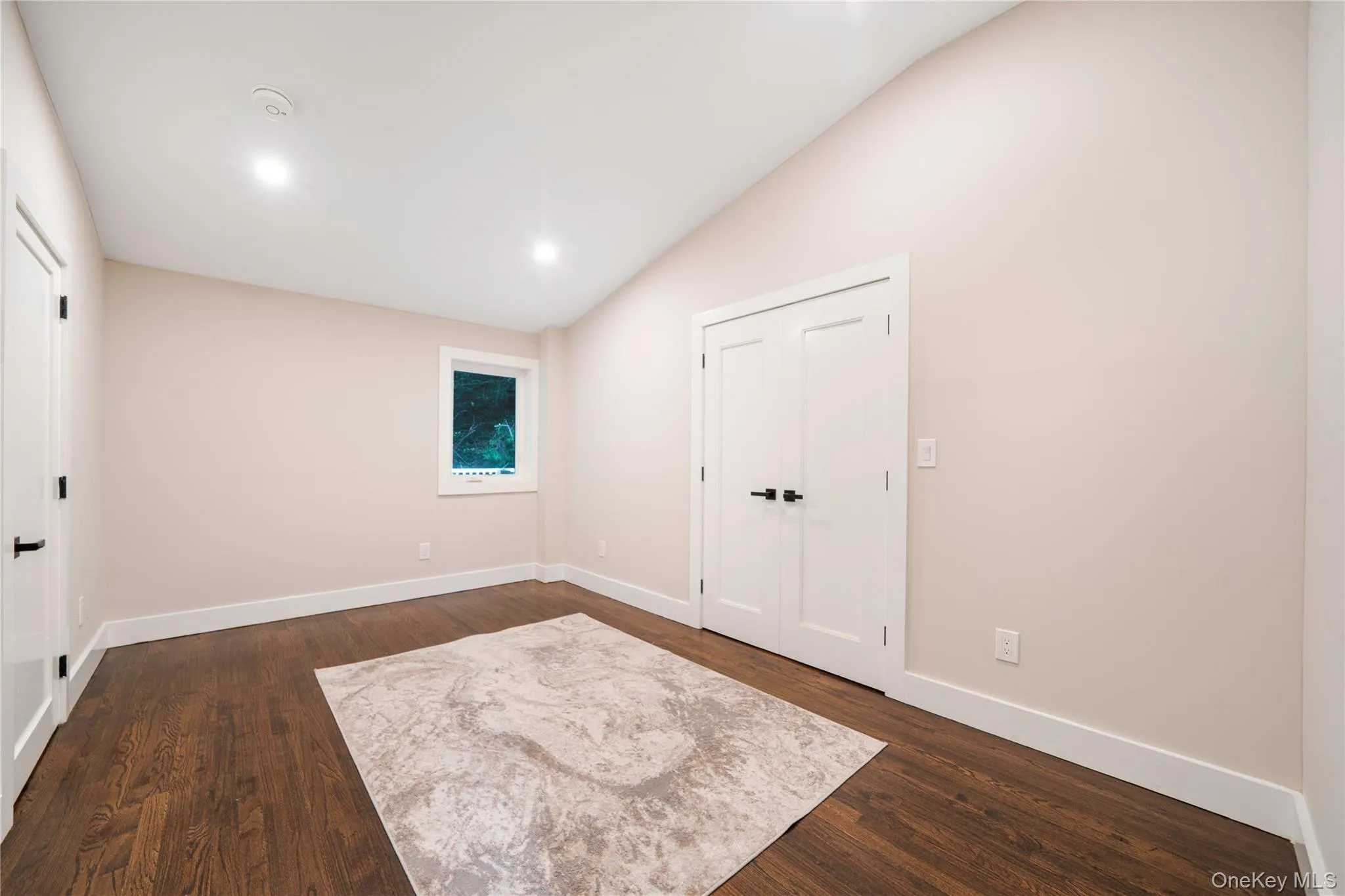 Unfurnished bedroom with lofted ceiling, dark wood-type flooring, and recessed lighting Unfurnished bedroom with lofted ceiling, dark wood-type flooring, and recessed lighting