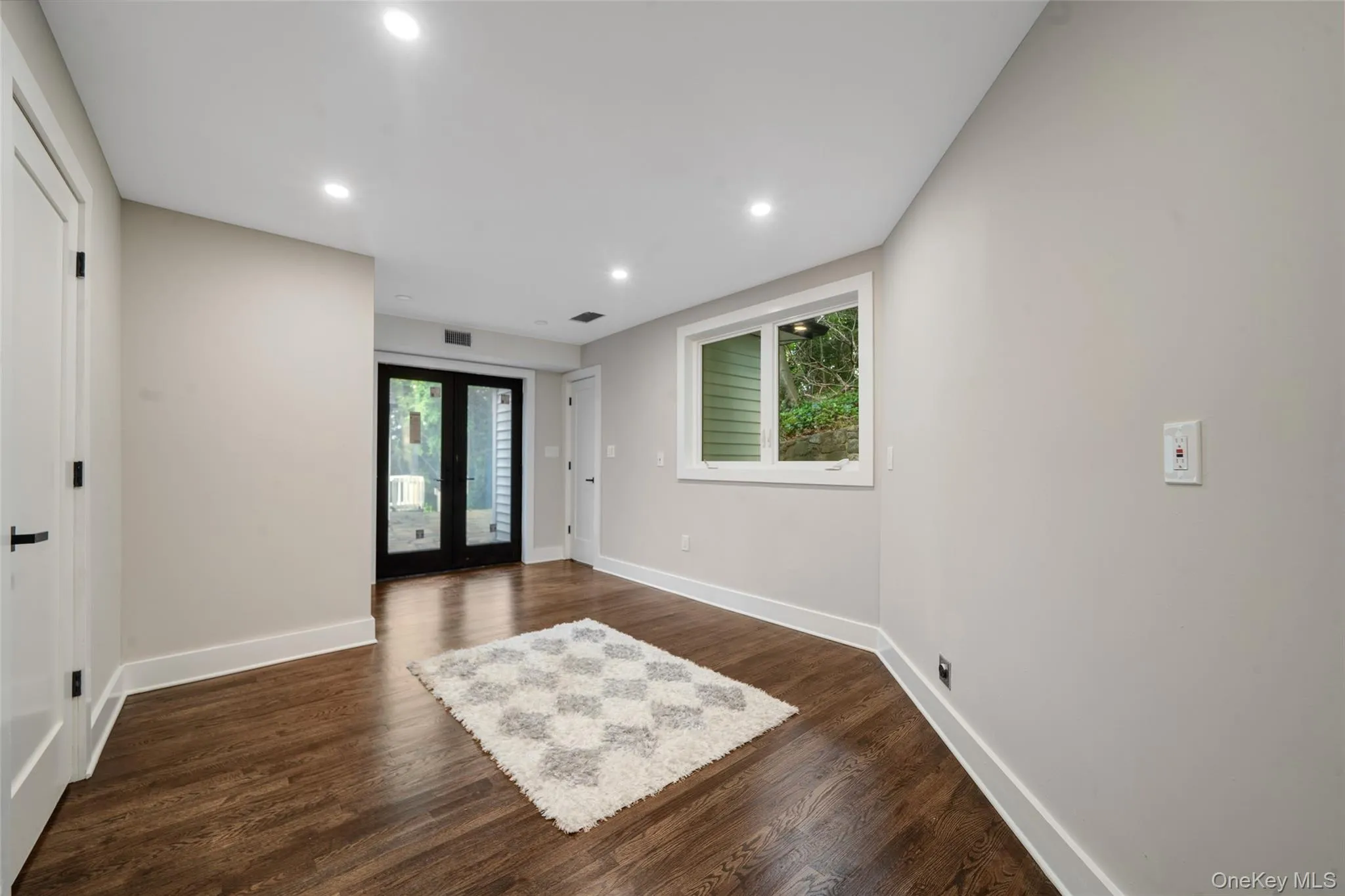 Foyer featuring plenty of natural light, recessed lighting, dark wood-type flooring, and french doors Foyer featuring plenty of natural light, recessed lighting, dark wood-type flooring, and french doors
