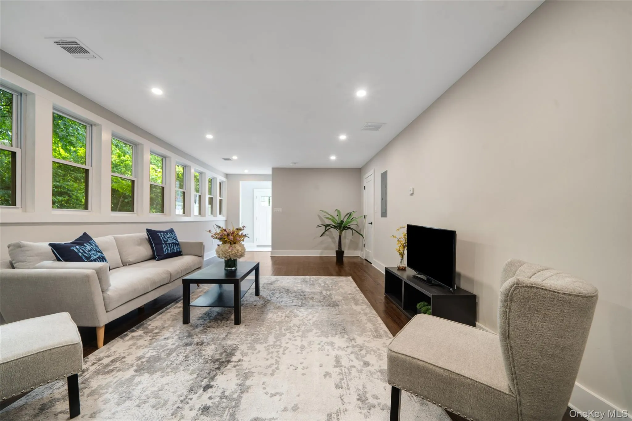 Living area with recessed lighting, dark wood-style floors, and healthy amount of natural light Living area with recessed lighting, dark wood-style floors, and healthy amount of natural light