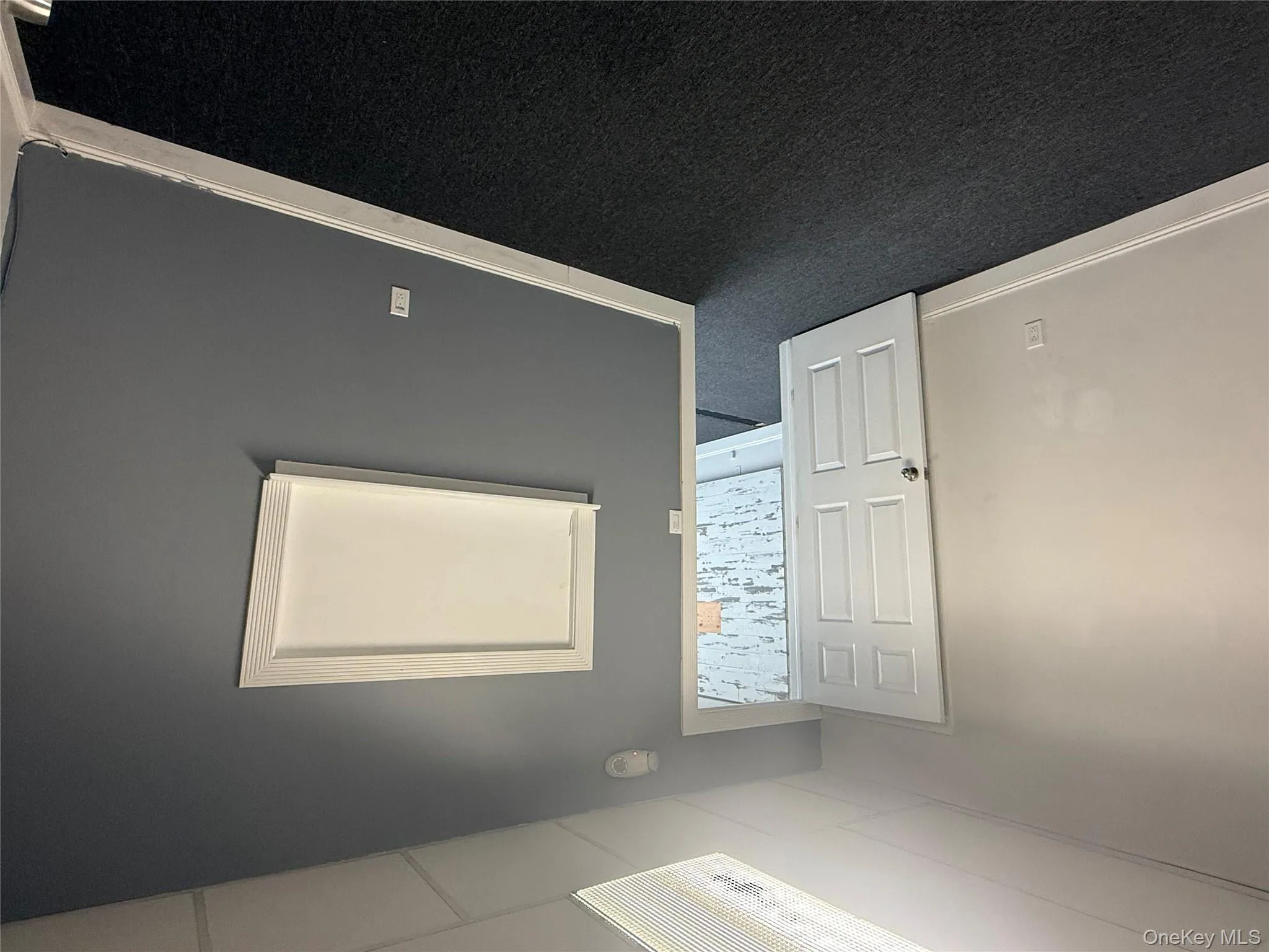 Spare room featuring dark carpet and a smoke detector Spare room featuring dark carpet and a smoke detector