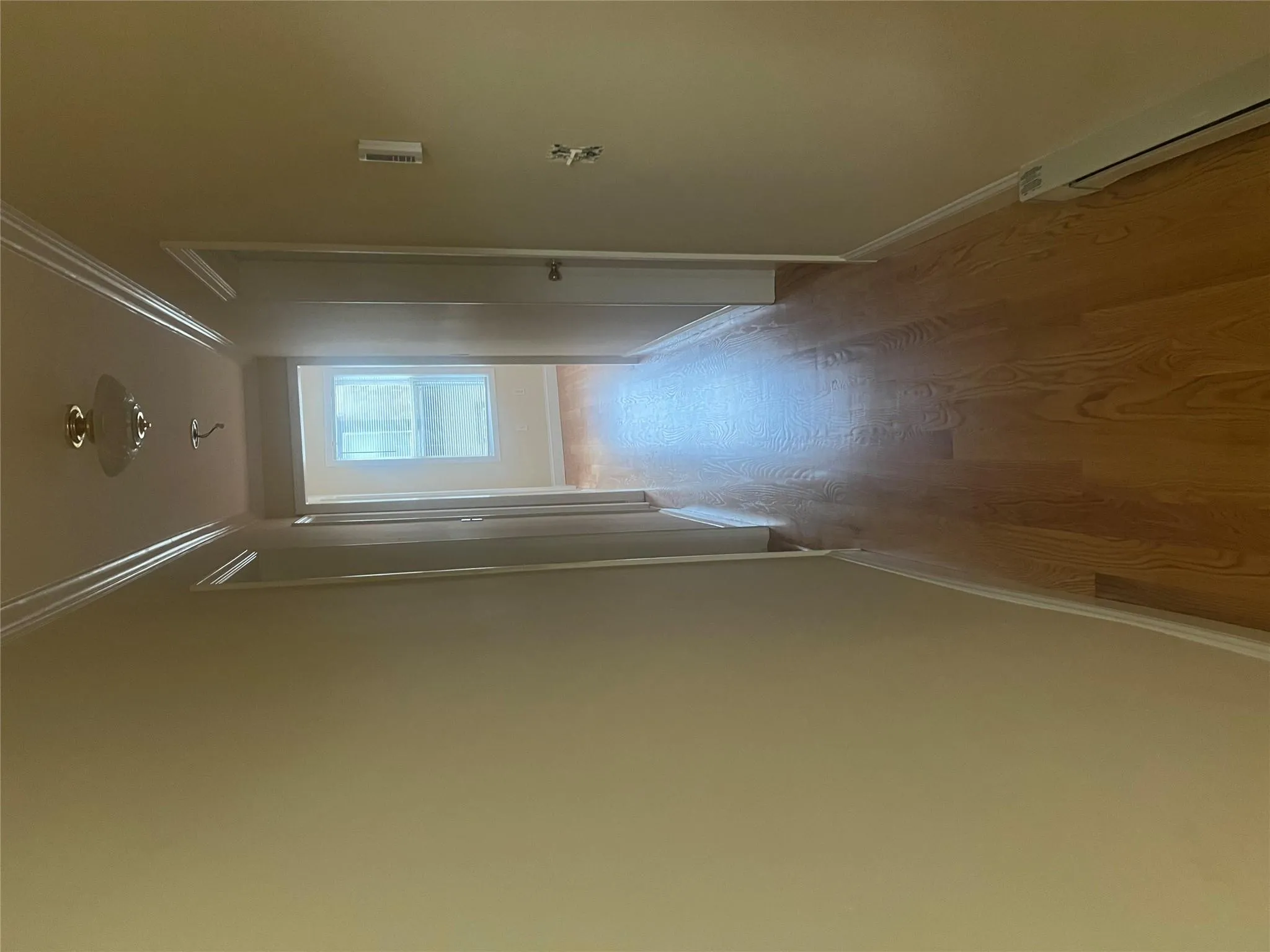 Hallway with crown molding, light wood-type flooring, and baseboard heating Hallway with crown molding, light wood-type flooring, and baseboard heating
