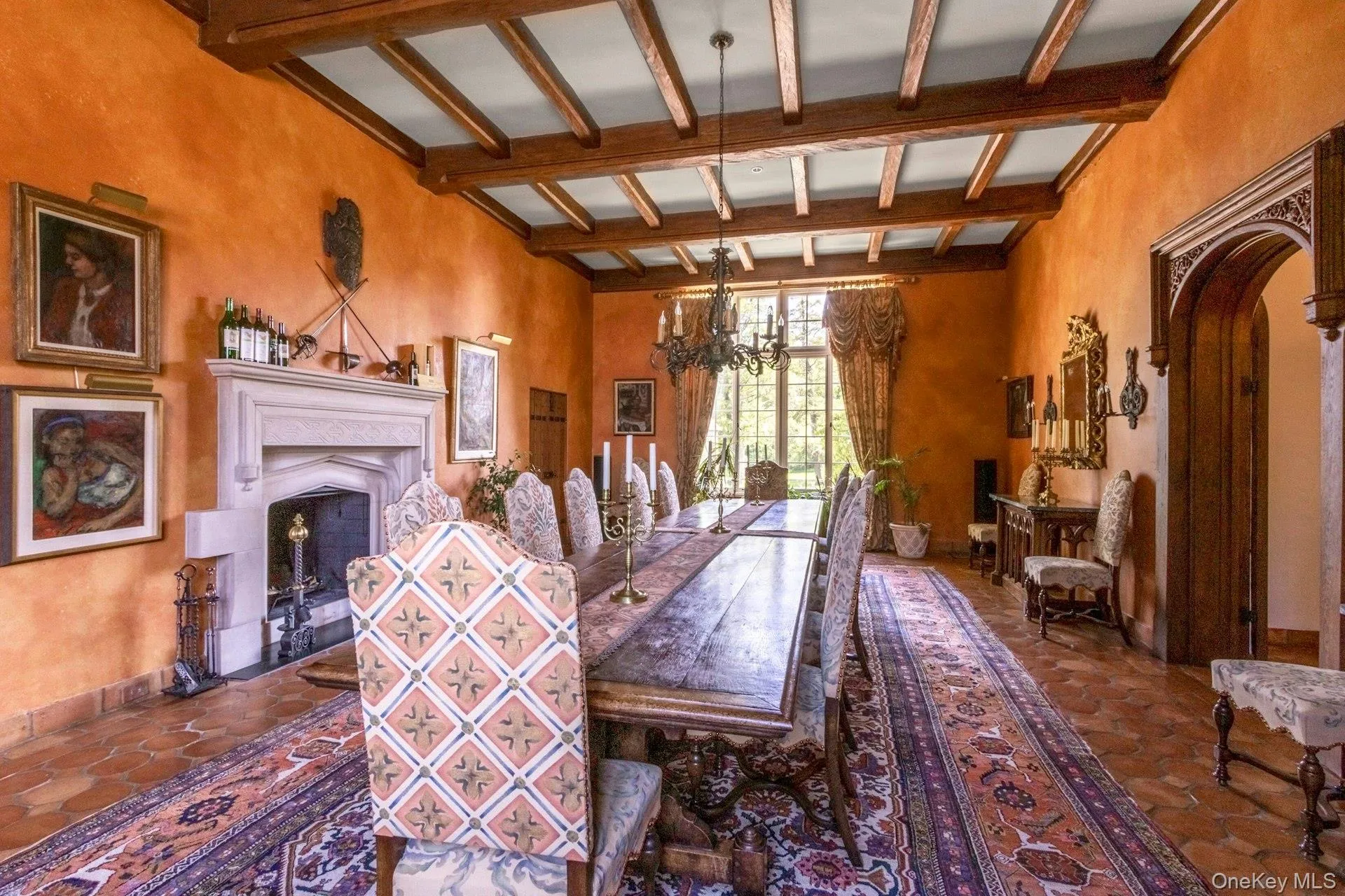 Dining room with beamed ceiling, arched walkways, a fireplace, and a chandelier Dining room with beamed ceiling, arched walkways, a fireplace, and a chandelier