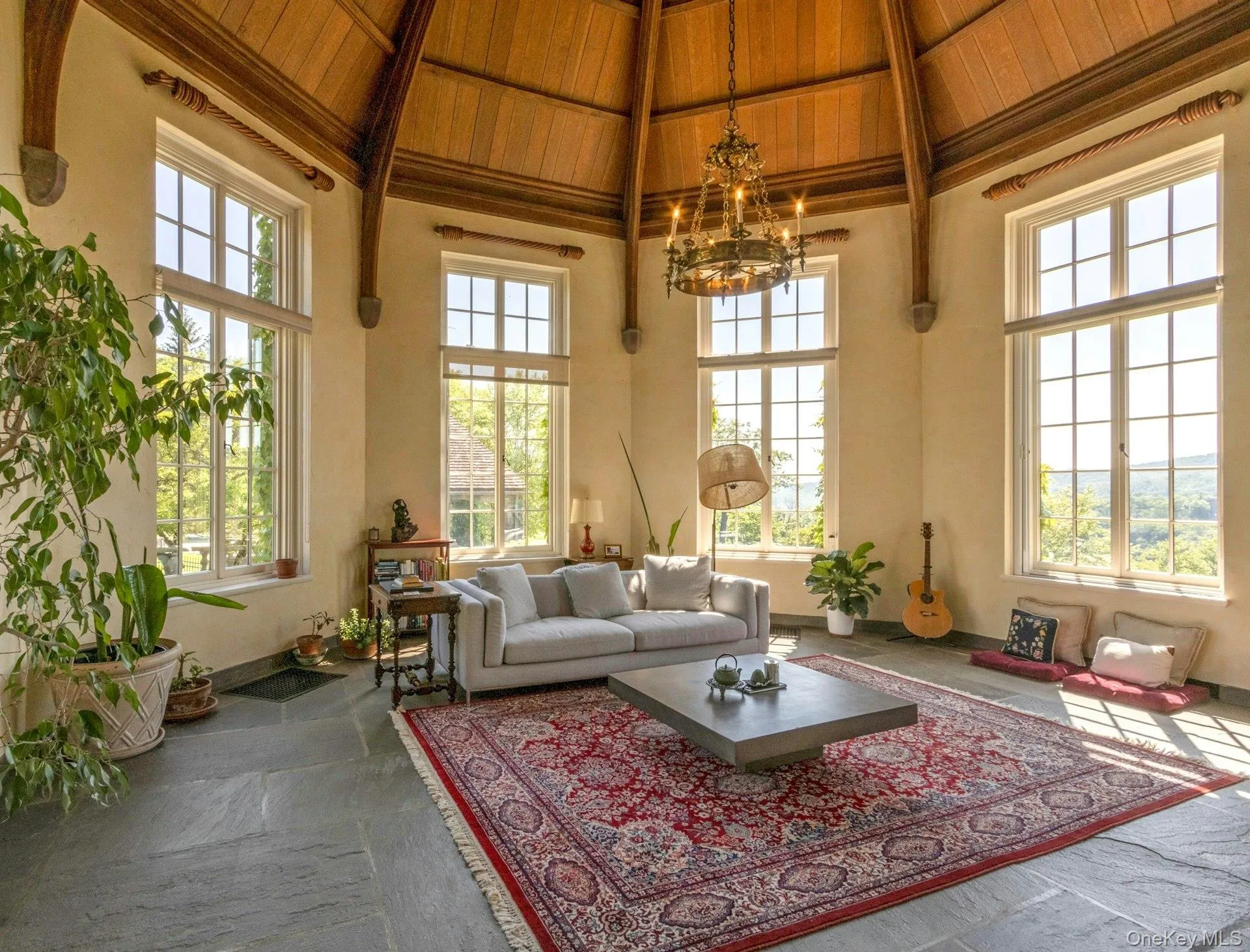 Living area with a chandelier, high vaulted ceiling, a wooden ceiling with exposed beams, and healthy amount of natural light Living area with a chandelier, high vaulted ceiling, a wooden ceiling with exposed beams, and healthy amount of natural light