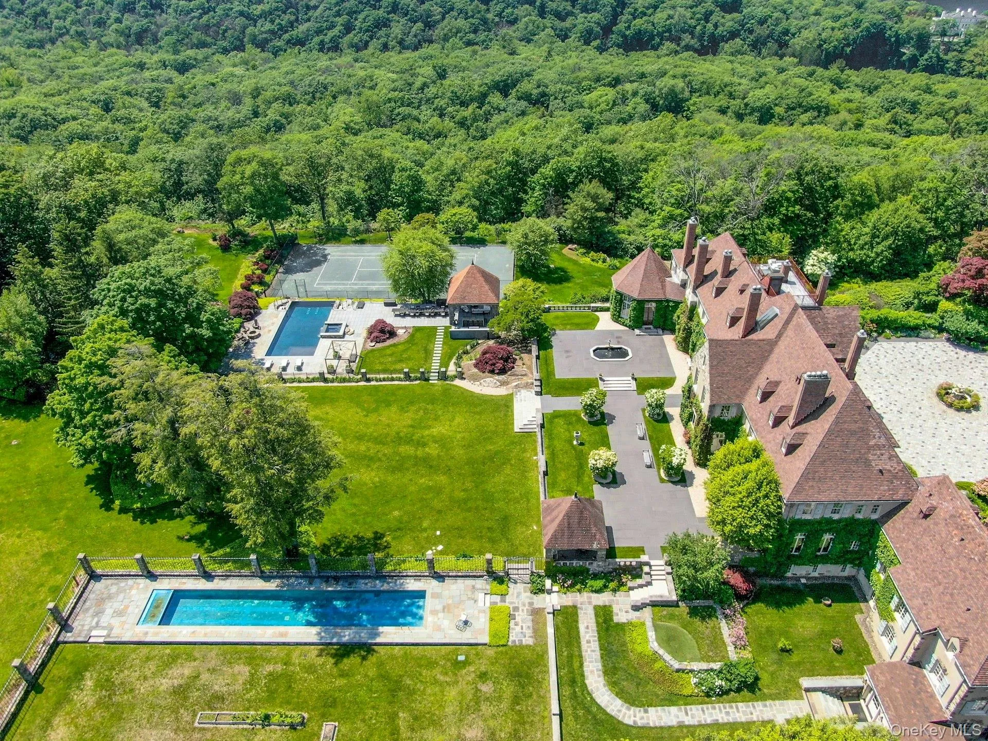Bird's eye view of a pool area and a heavily wooded area Bird's eye view of a pool area and a heavily wooded area
