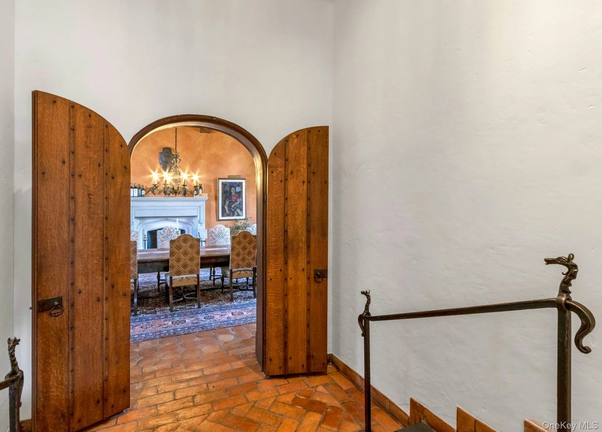 Corridor featuring arched walkways, brick flooring, and a chandelier Corridor featuring arched walkways, brick flooring, and a chandelier