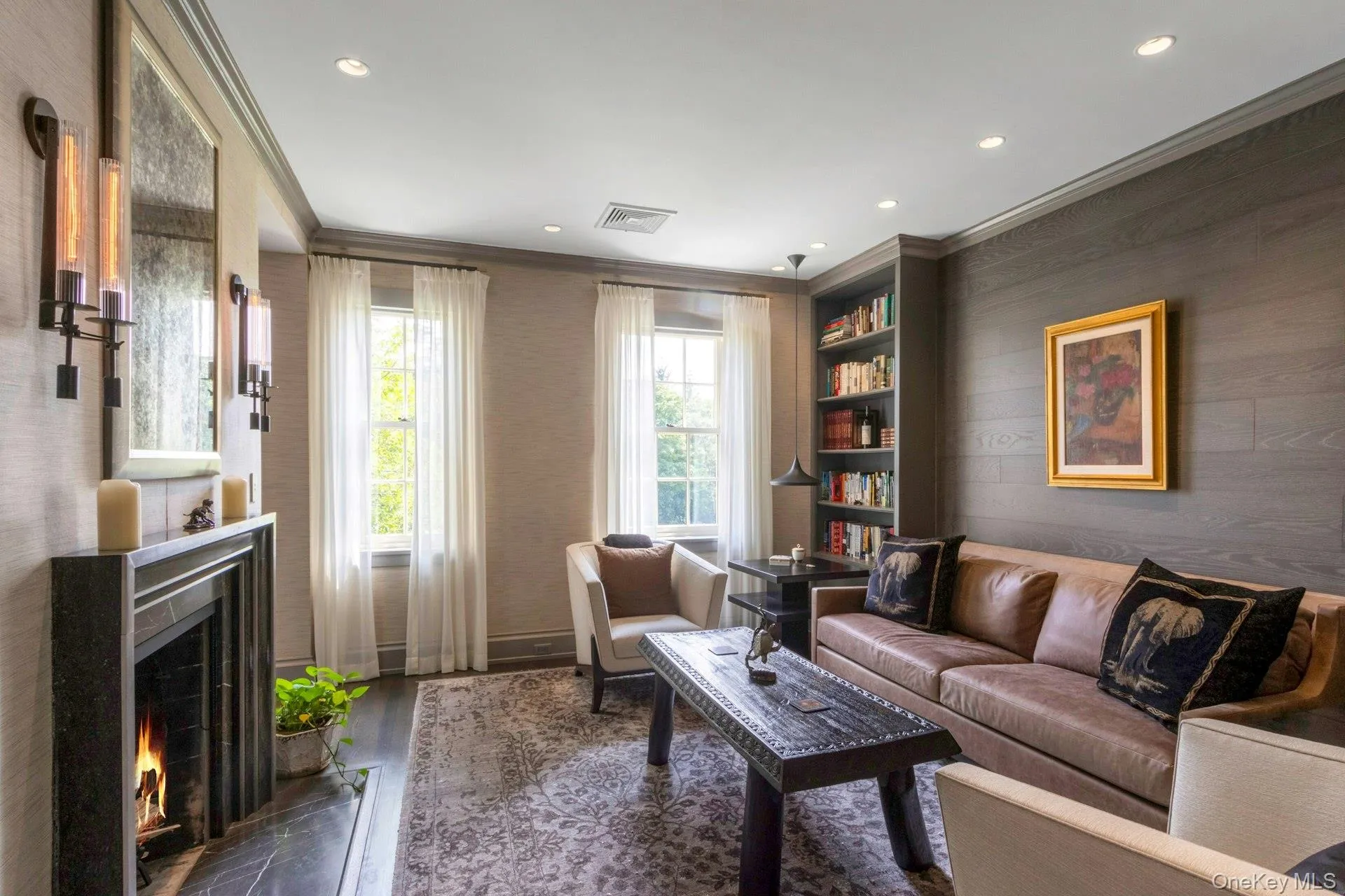 Sitting room with crown molding, dark wood-style flooring, a premium fireplace, and recessed lighting Sitting room with crown molding, dark wood-style flooring, a premium fireplace, and recessed lighting