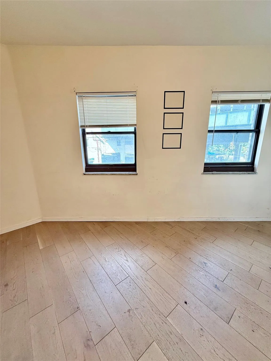 Empty room featuring healthy amount of natural light and hardwood / wood-style floors Empty room featuring healthy amount of natural light and hardwood / wood-style floors