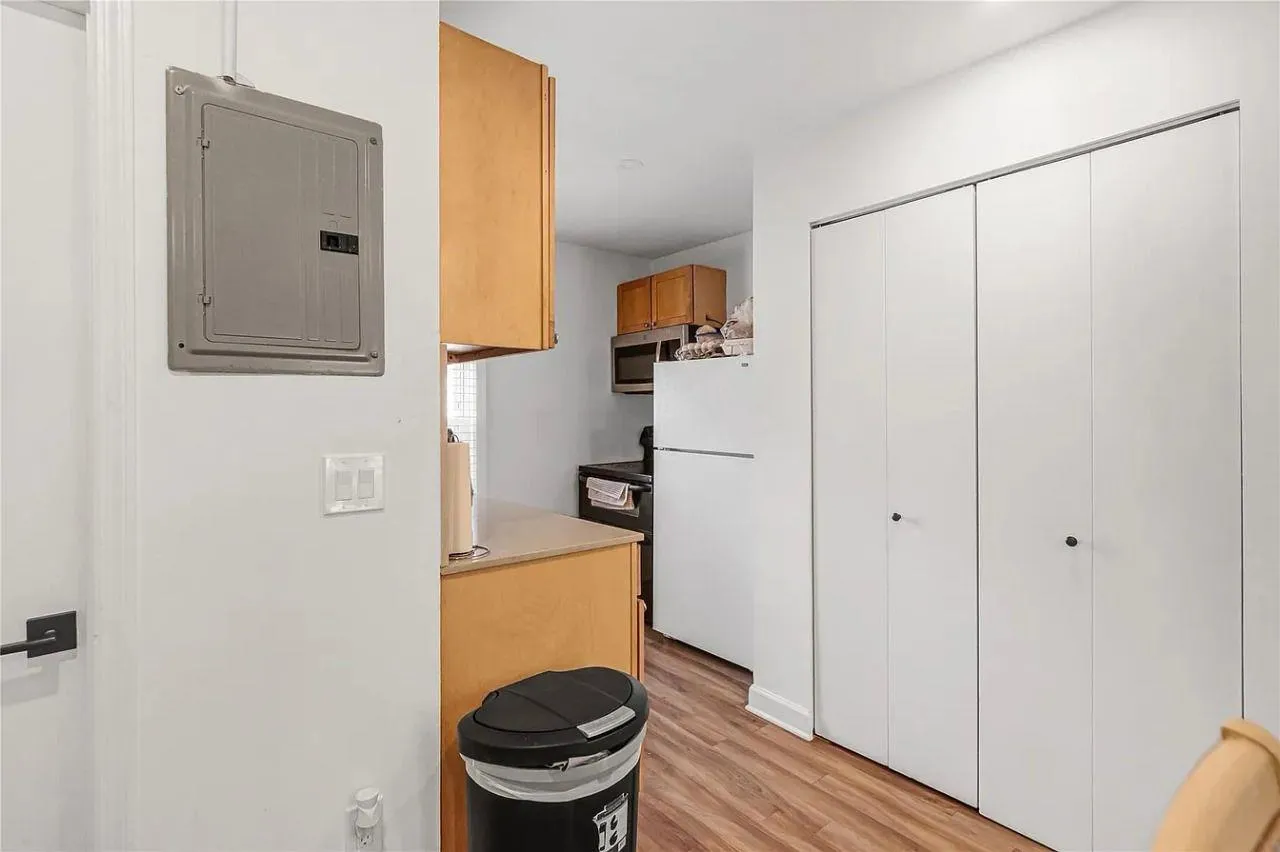 Kitchen featuring freestanding refrigerator, electric panel, light wood finished floors, stainless steel microwave, and range Kitchen featuring freestanding refrigerator, electric panel, light wood finished floors, stainless steel microwave, and range