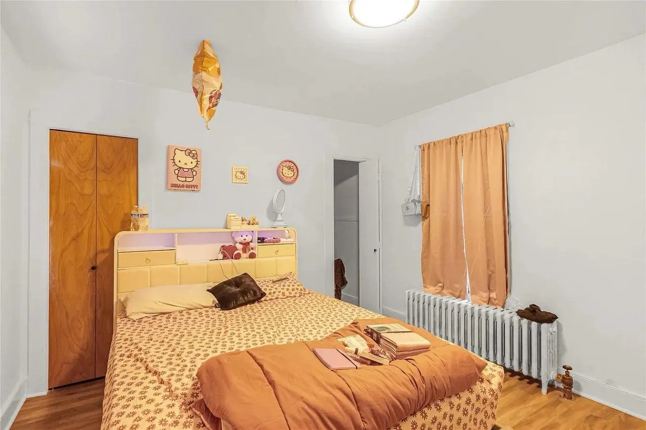 Bedroom featuring radiator heating unit and wood finished floors Bedroom featuring radiator heating unit and wood finished floors